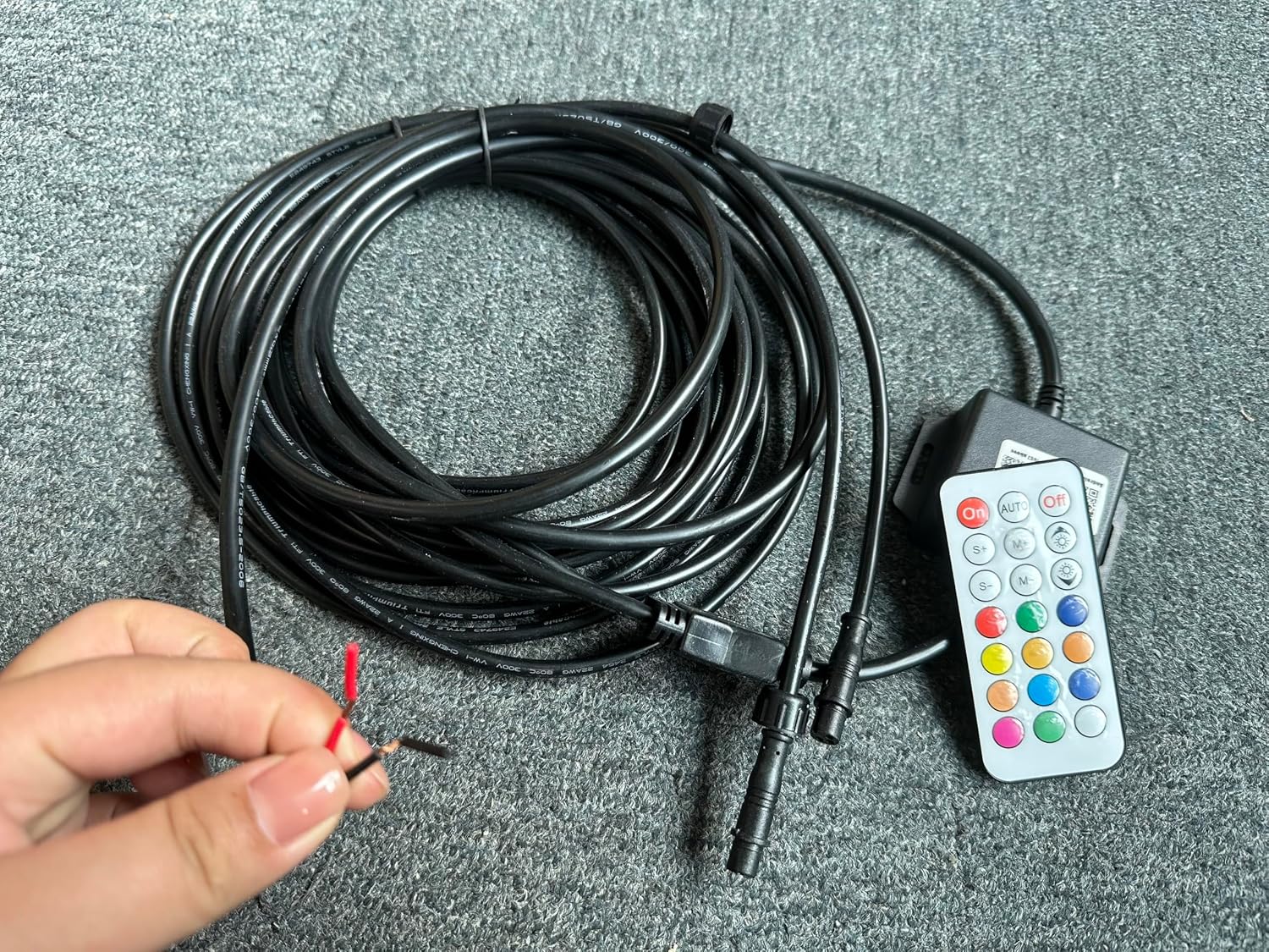 Hand holding two 3-pin connectors from the wire set