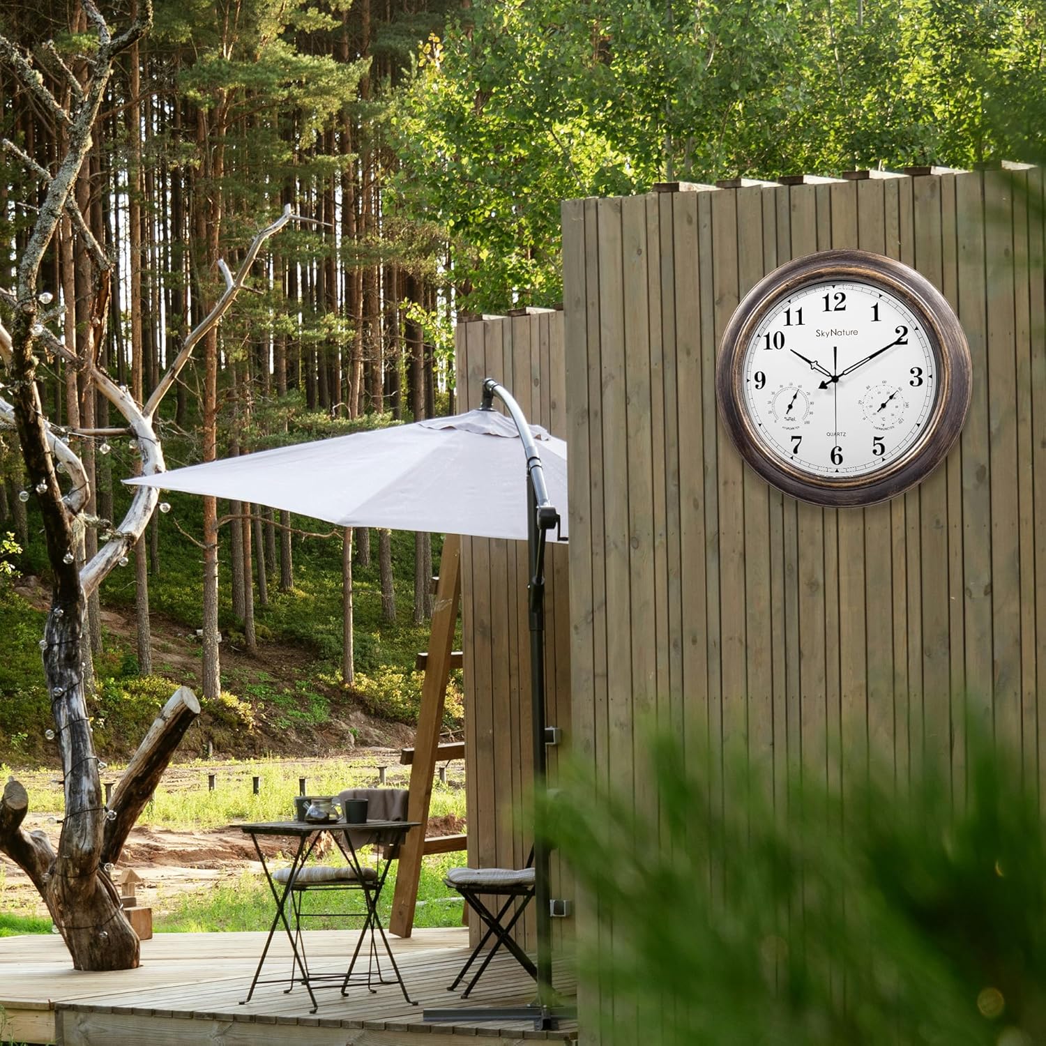 Outdoor clock mounted on a wooden fence in a garden setting.