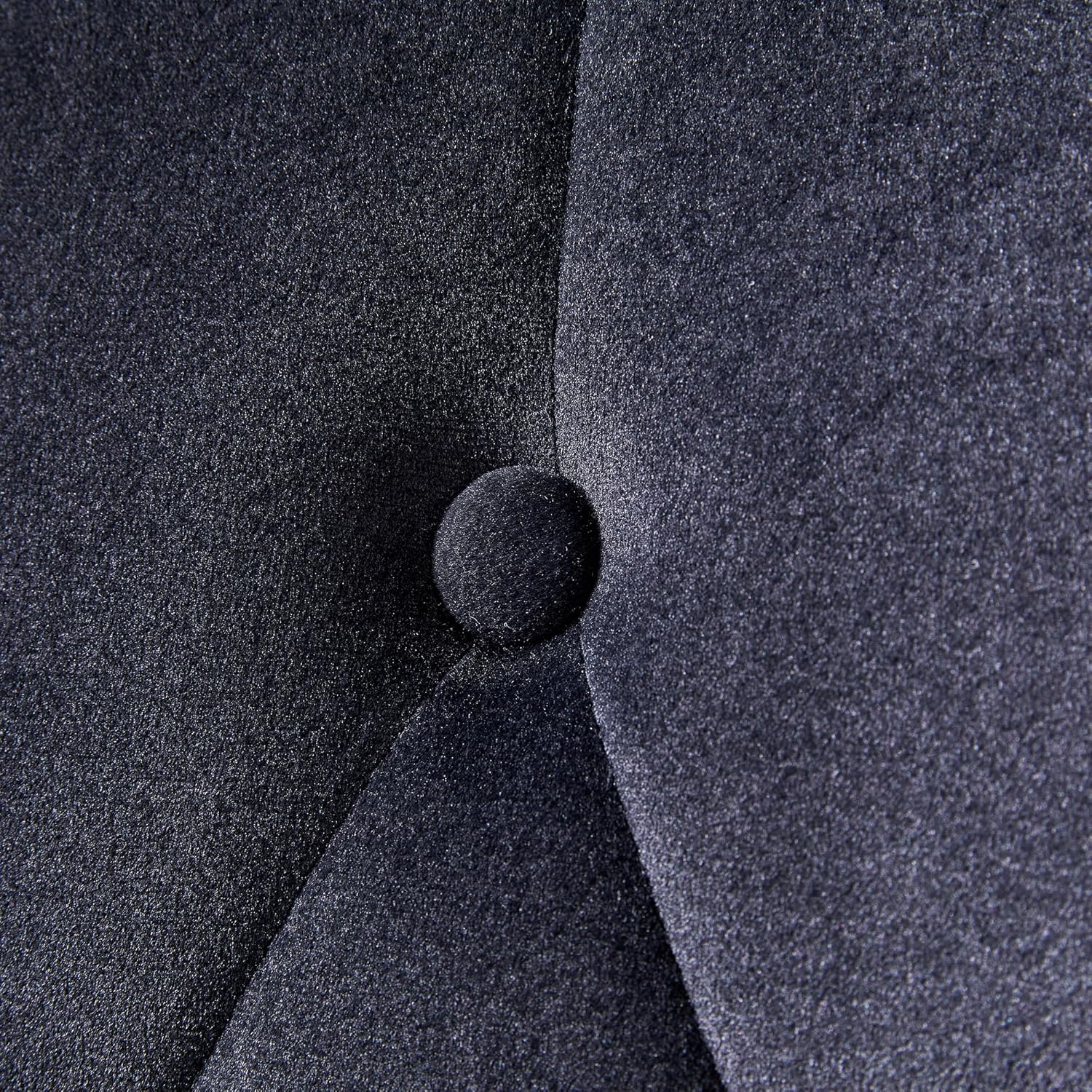 Extreme close-up of the velvet fabric and a single stud on the chair's backrest.