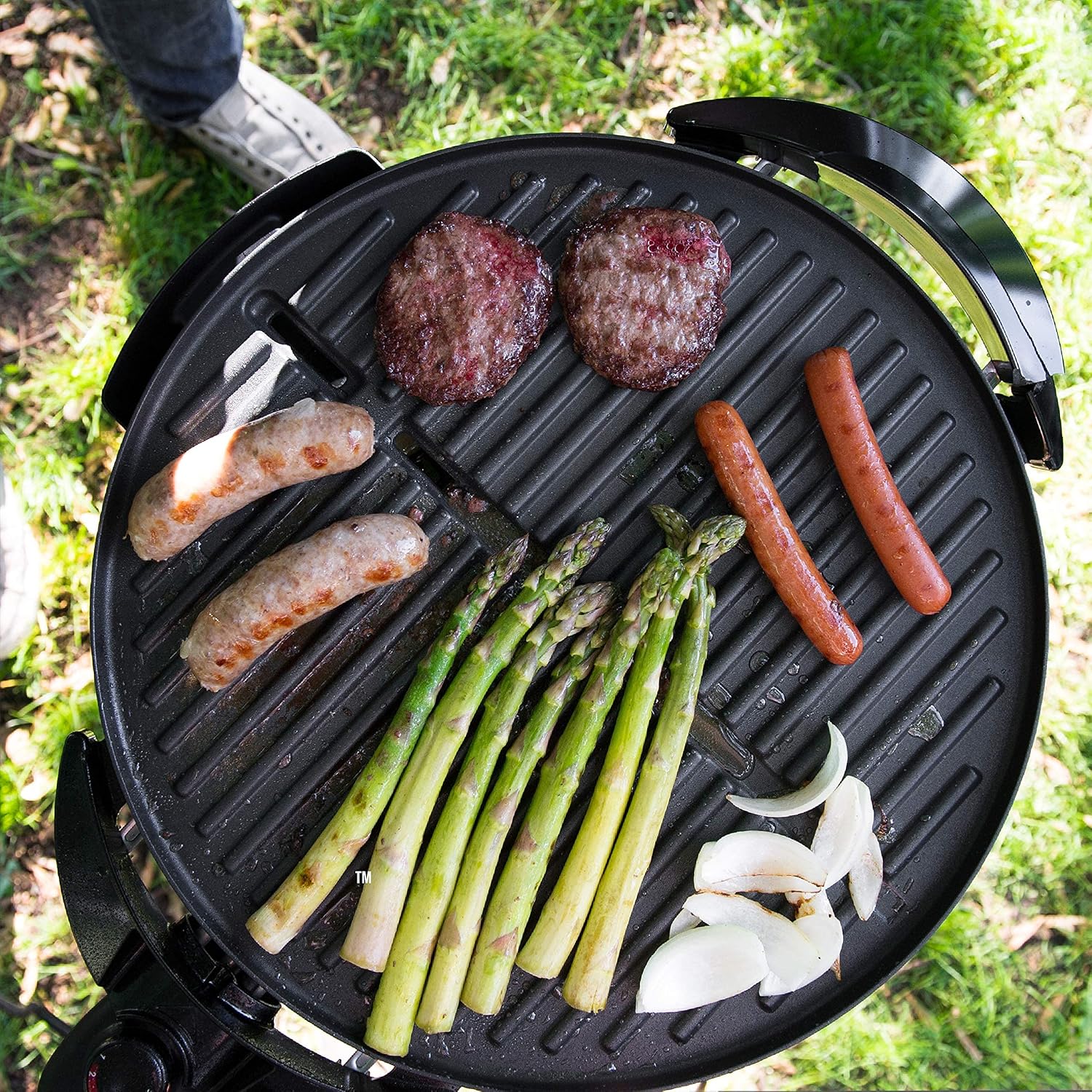 Overhead view of burgers, sausages, asparagus, and onions grilling on the George Foreman GIO2000BK Electric Grill