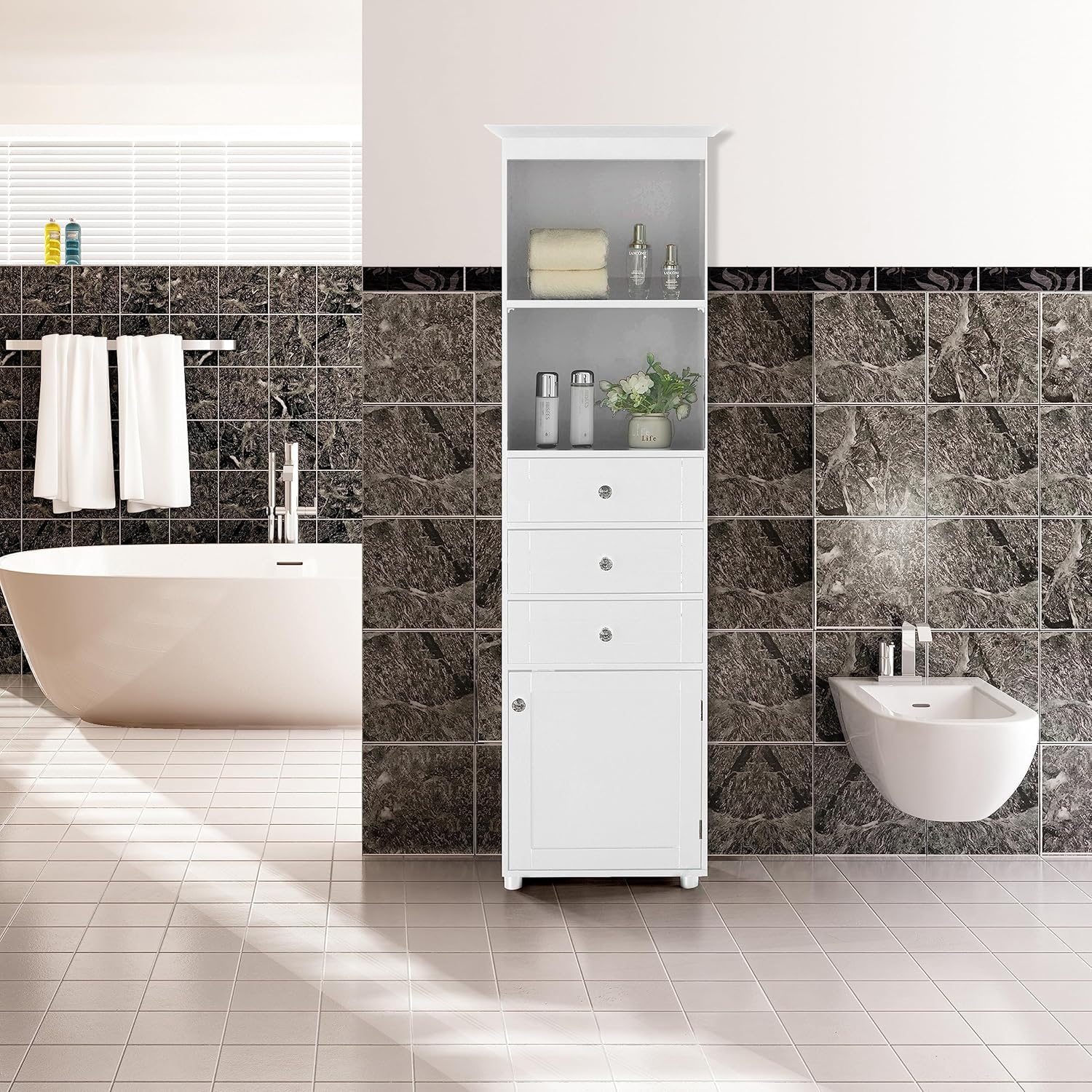 White linen tower placed in a modern bathroom setting next to a bathtub and bidet, showcasing its freestanding design and storage capabilities.