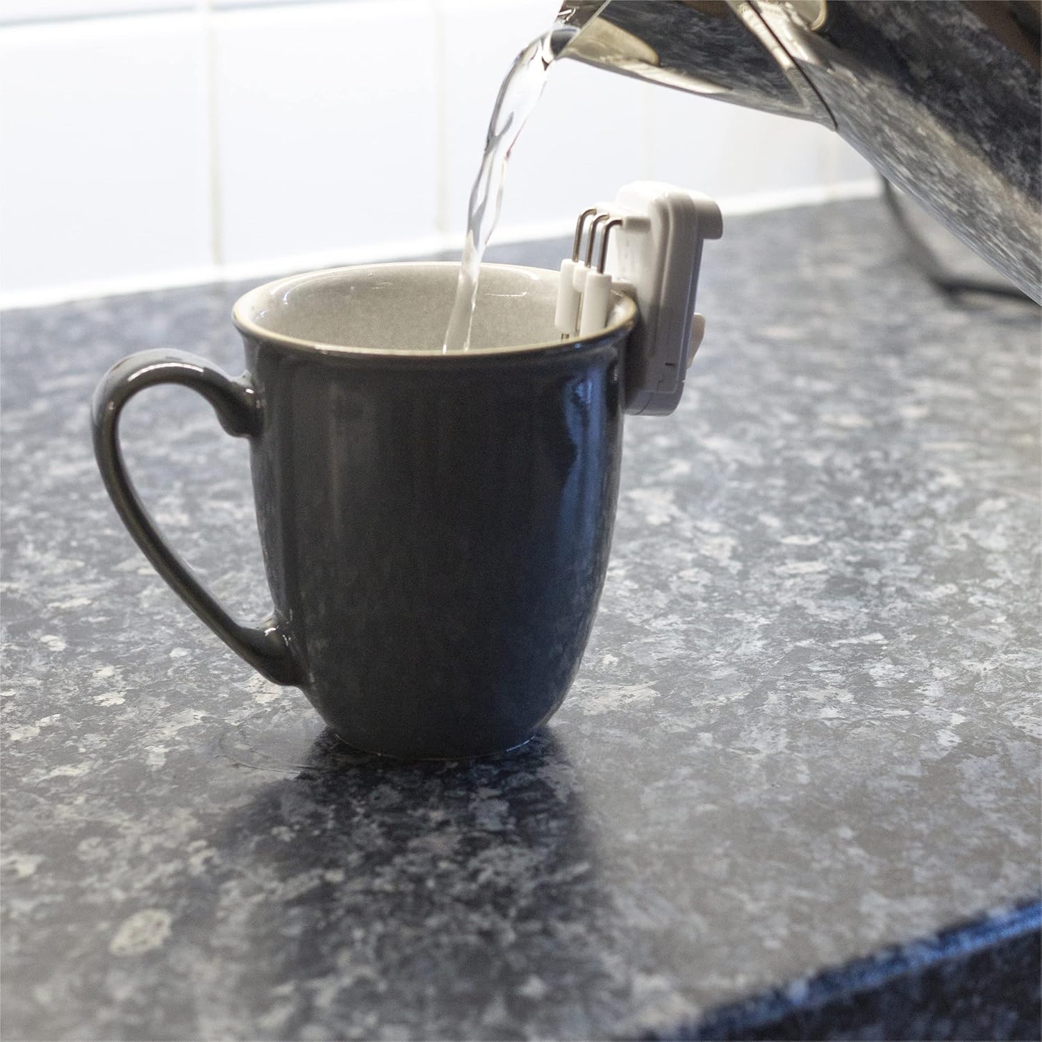 Water being poured into a mug with the Aidapt Liquid Level Indicator clipped on, showing the liquid approaching the prongs.