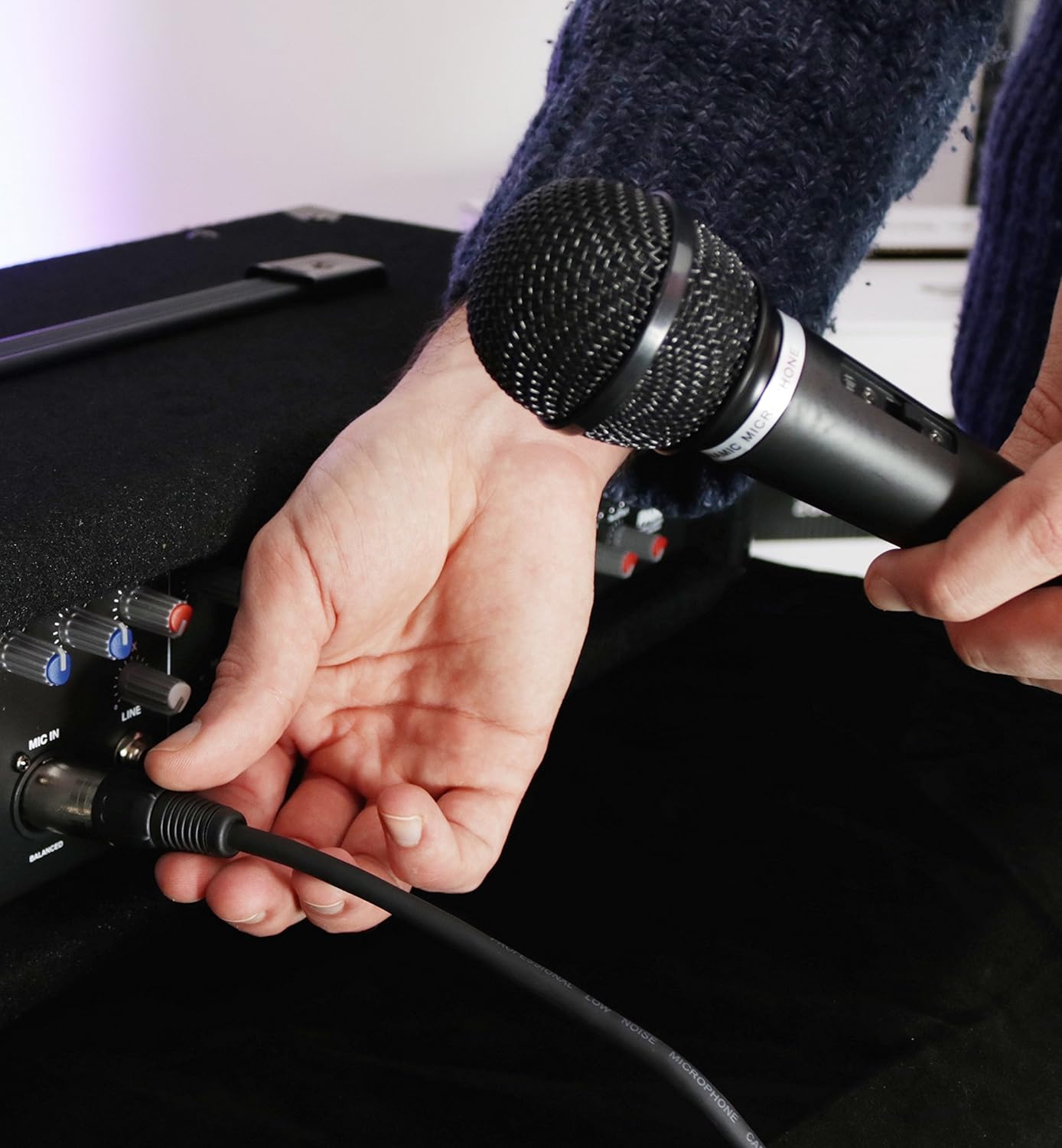 Person placing a speaker onto a speaker stand