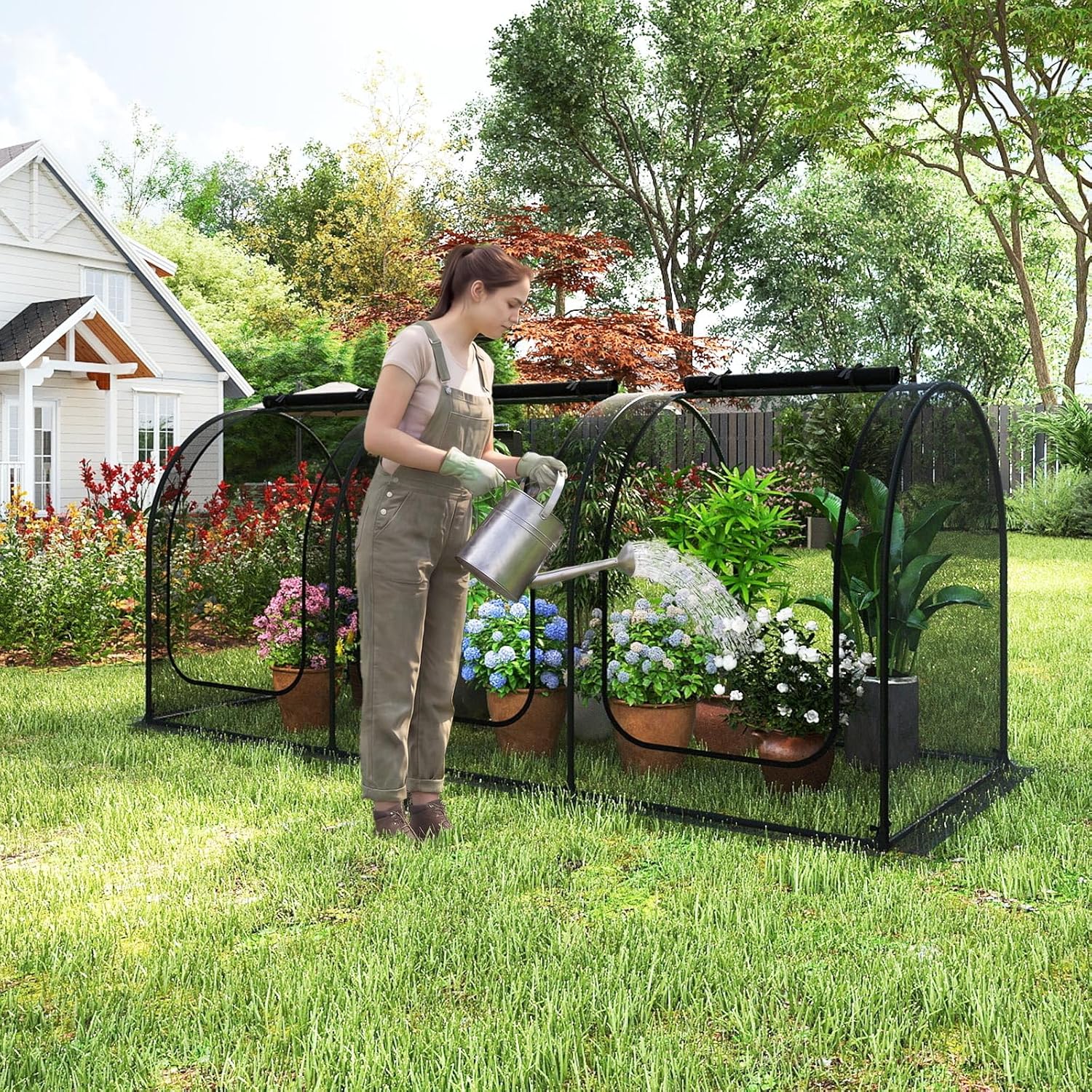 Woman watering plants inside the Happygrill Portable Crop Cage