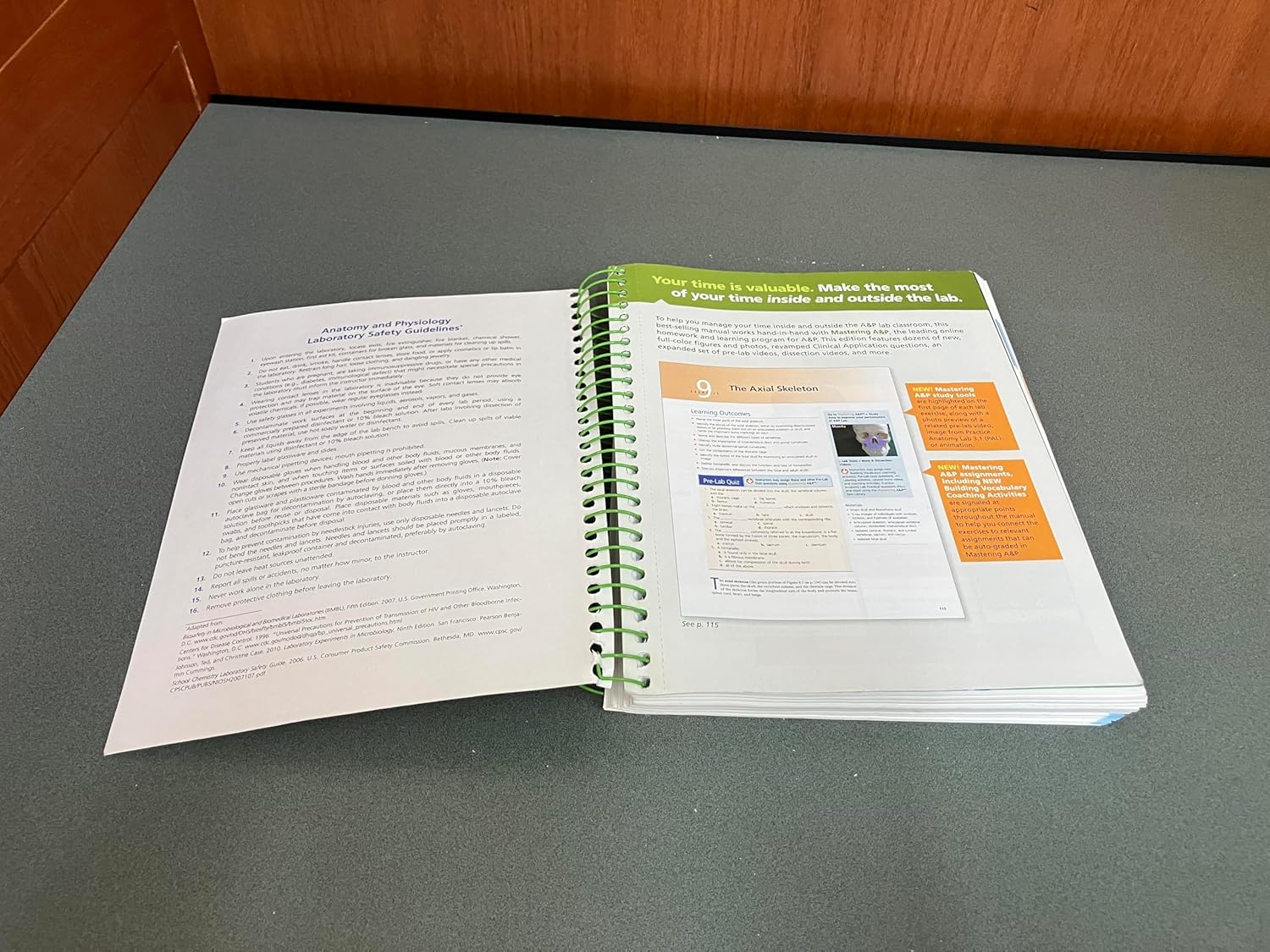 Open pages of Human Anatomy & Physiology Laboratory Manual, Main Version, 12th Edition, showing an exercise on the Axial Skeleton with diagrams and text.