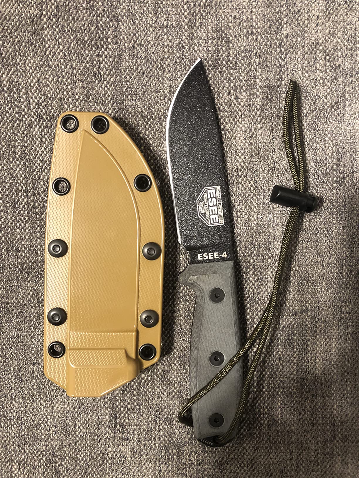 Fixed blade survival knife with sheath on forest floor