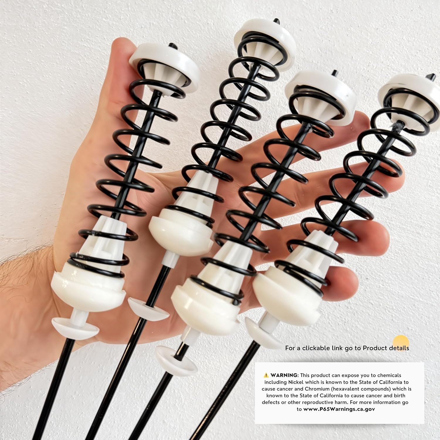 Hand holding suspension rods, with a Proposition 65 warning