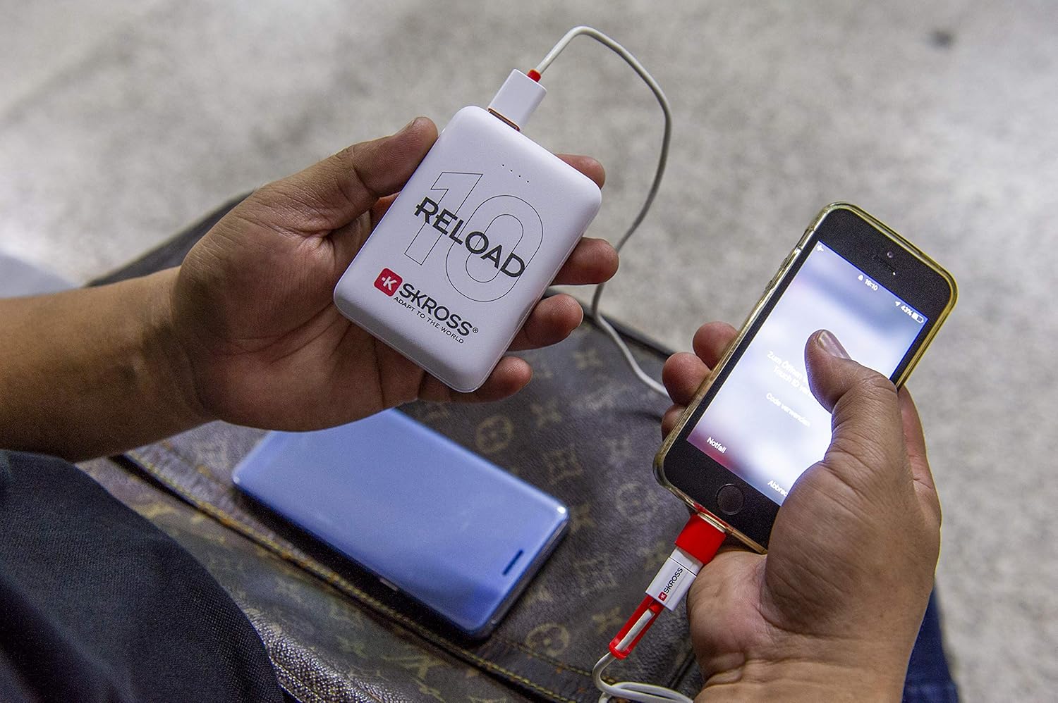 Башка view of a user charging a smartphone with the SKROSS Reload 10 Power Bank