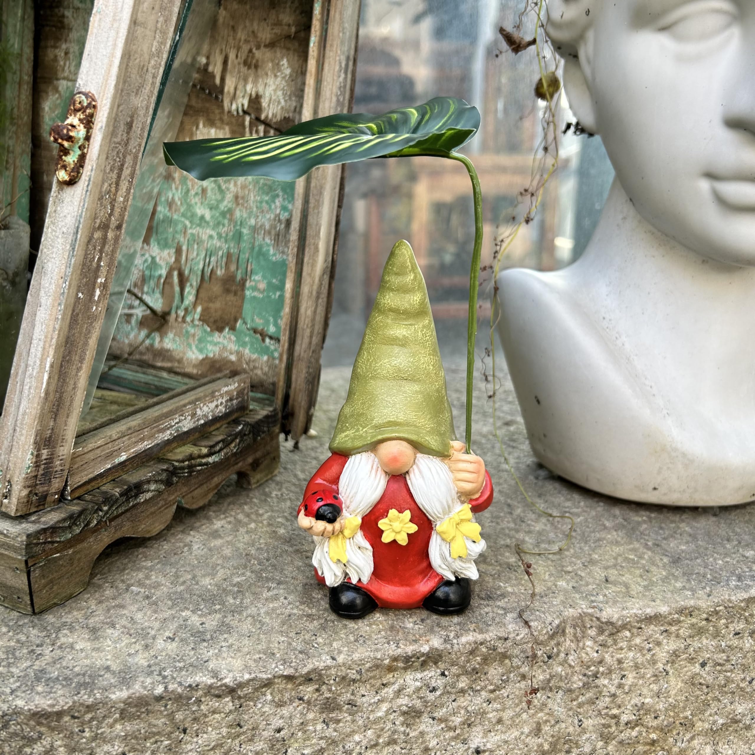 Gnomo de jardín con paraguas de hojas, figura decorativa, rojo y verde, con mariquita sosteniendo