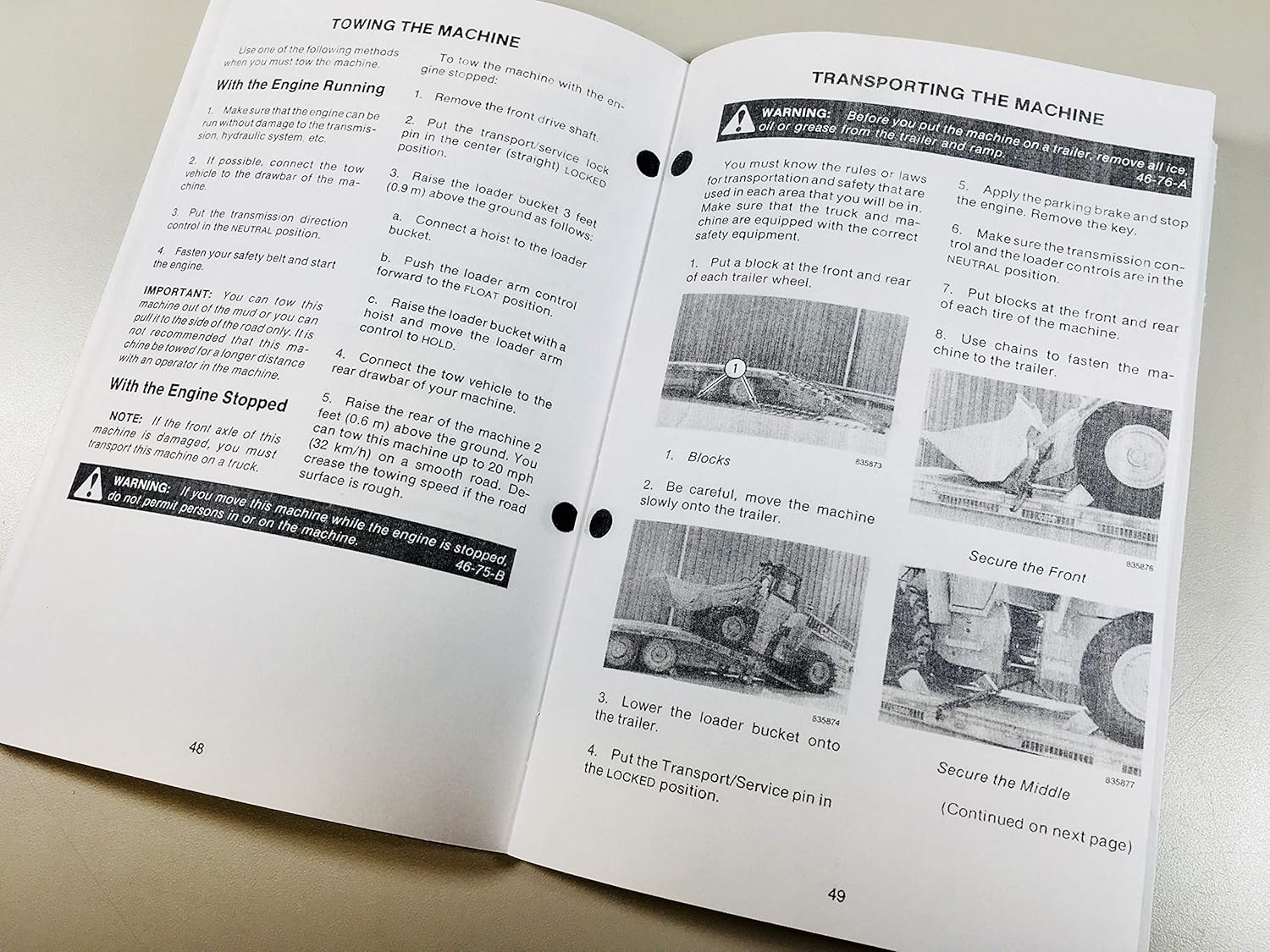 Pages from the manual showing instructions for towing and transporting the loader
