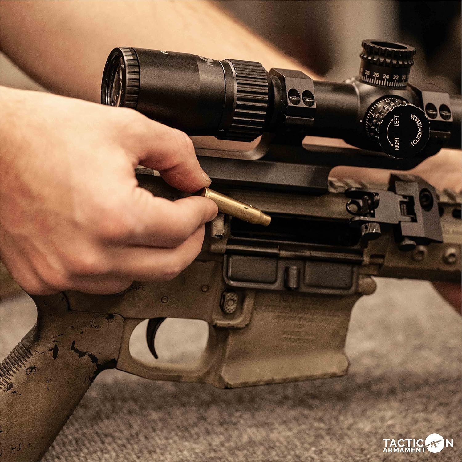 Hands inserting the Tacticon Laser Boresighter into the chamber of a rifle