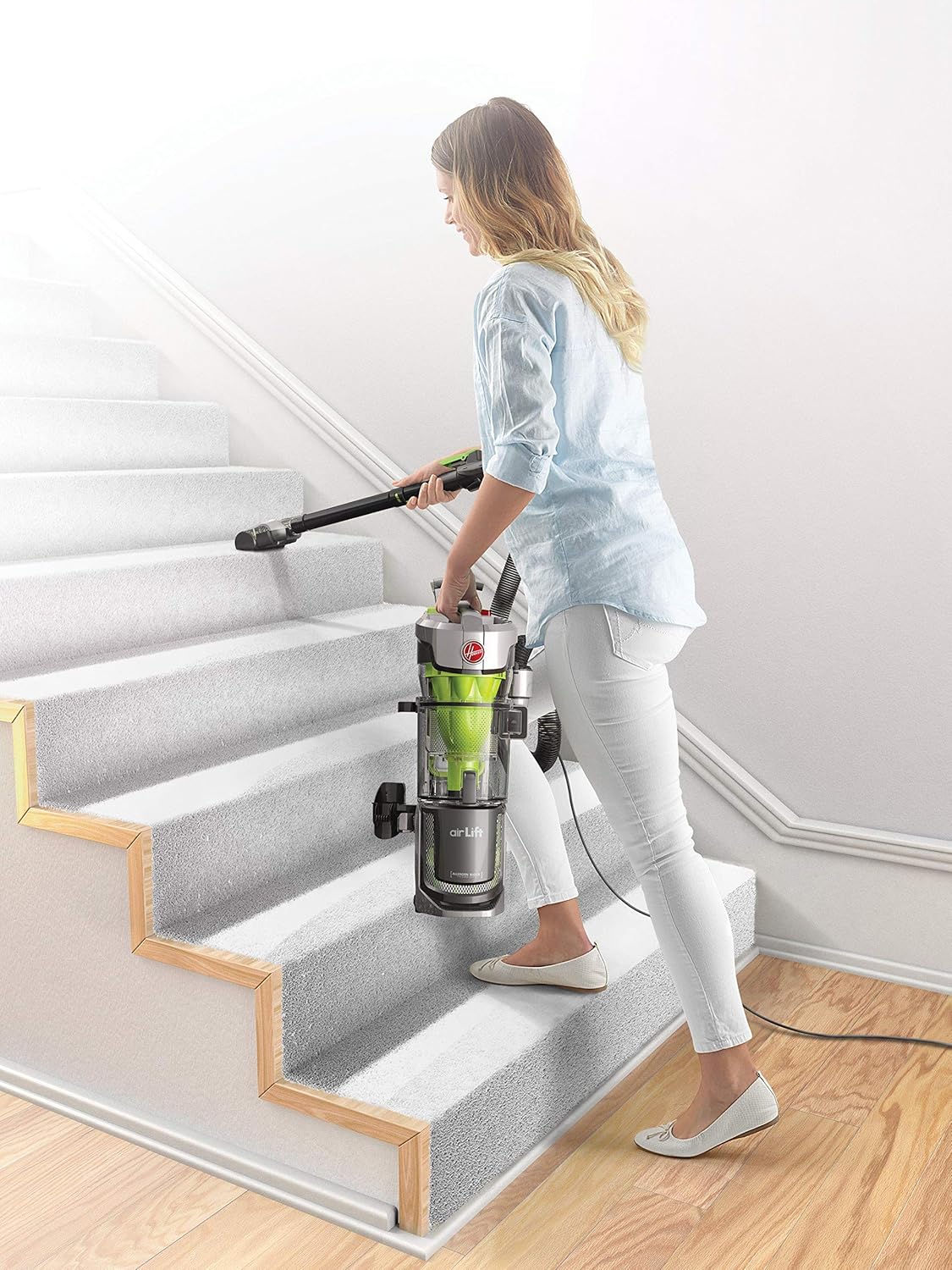 Woman using Hoover Air Lift Deluxe in lift-away mode to clean stairs