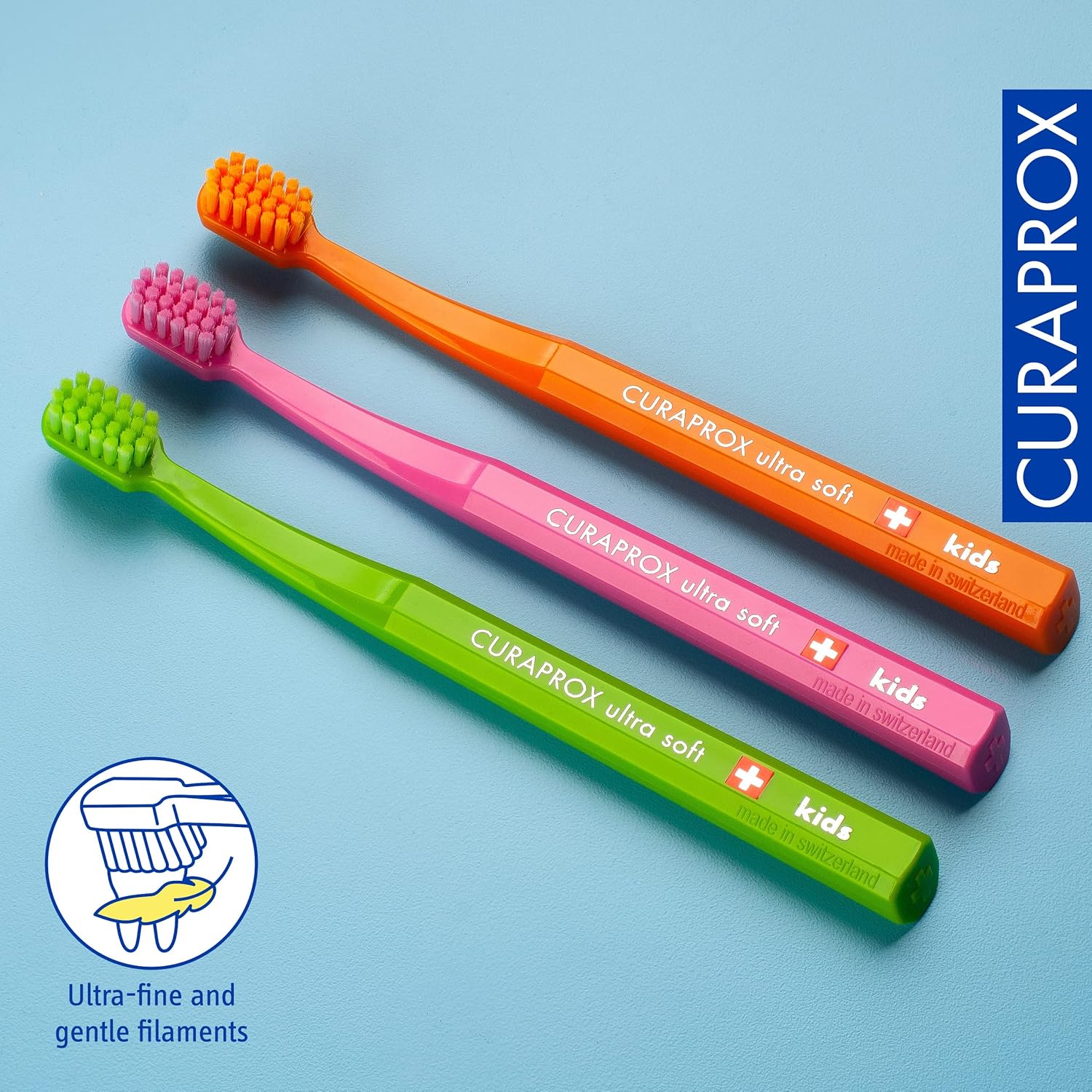 Three Curaprox CS Kids Toothbrushes in orange, pink, and green, showcasing the ultra-fine and gentle filaments.