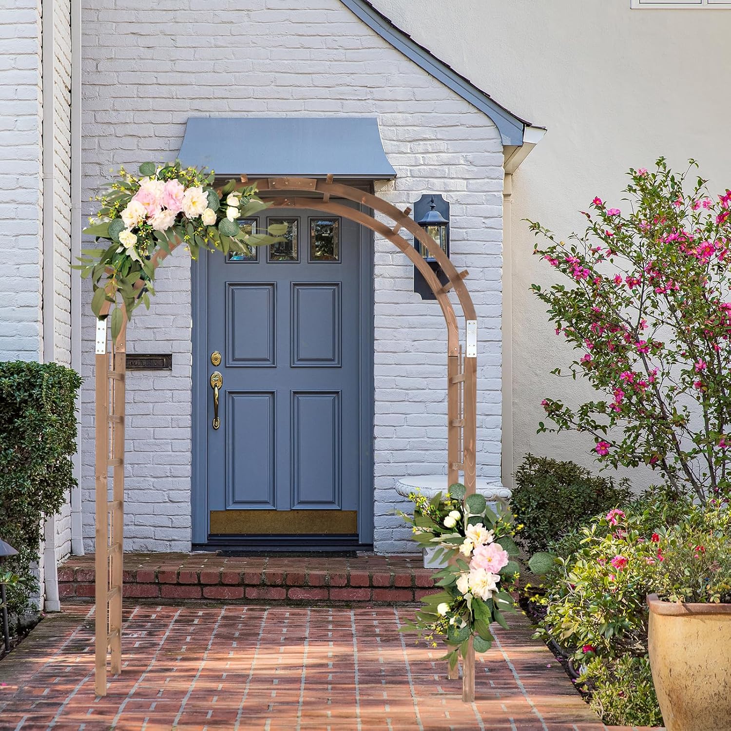 VINGLI Wooden Garden Arbor decorated with flowers, placed at the entrance of a house.