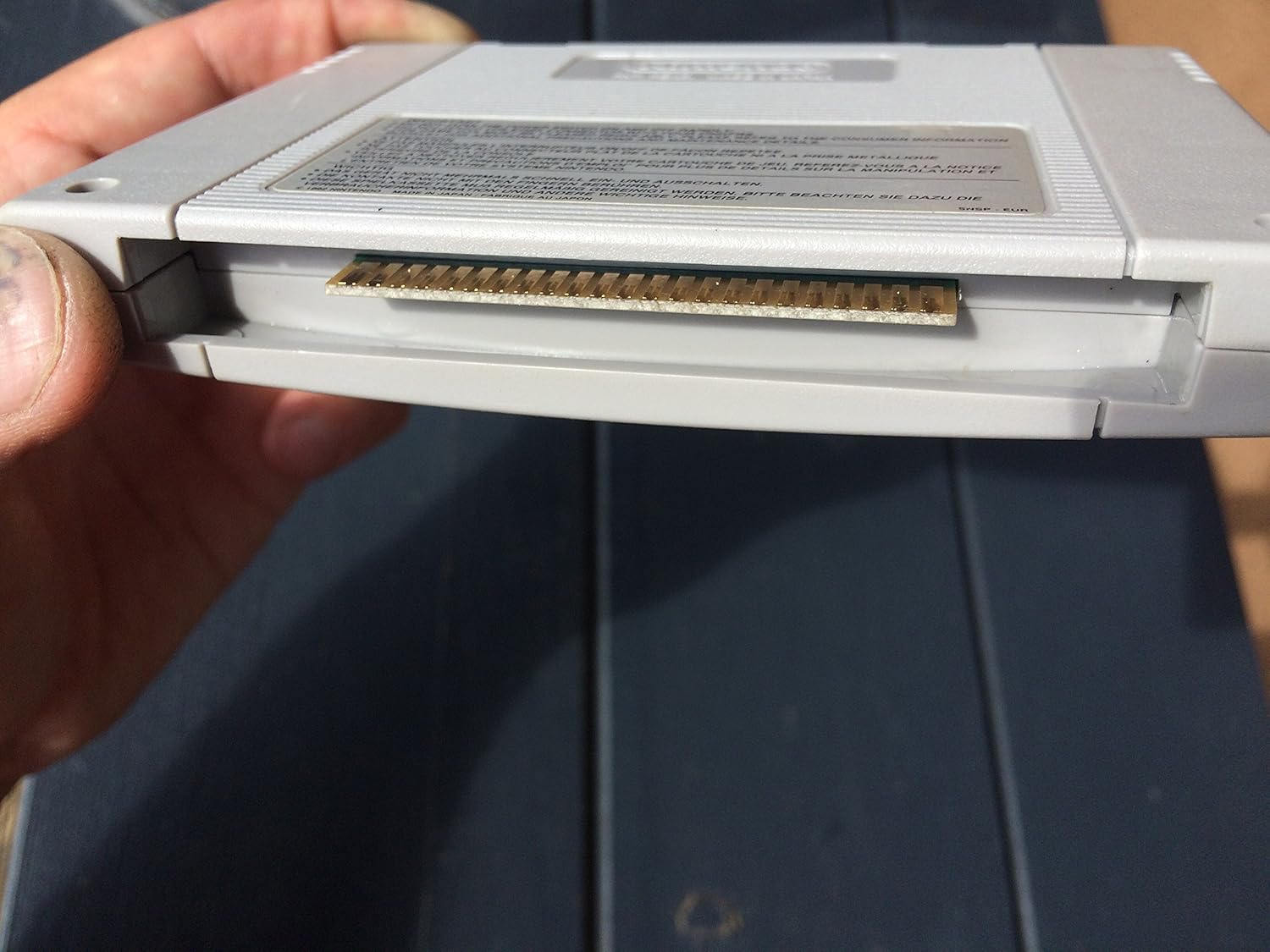 Nærbillede view of the gold-plated connector pins at the bottom of the Super Nintendo game cartridge.