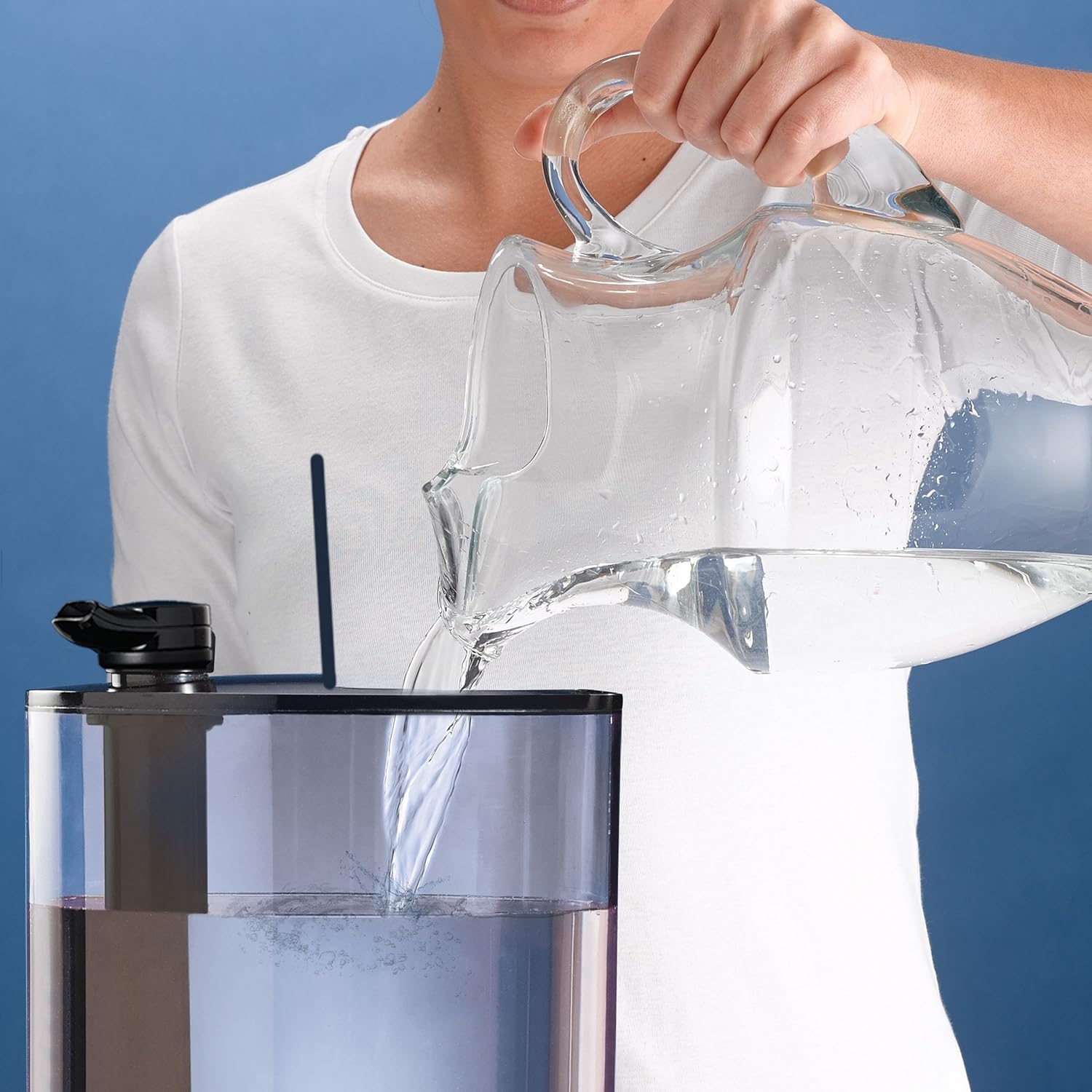 Person pouring water into the top of the humidifier