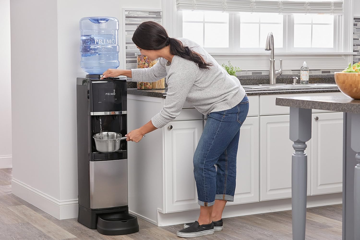 Woman filling a pot with hot water from the dispenser