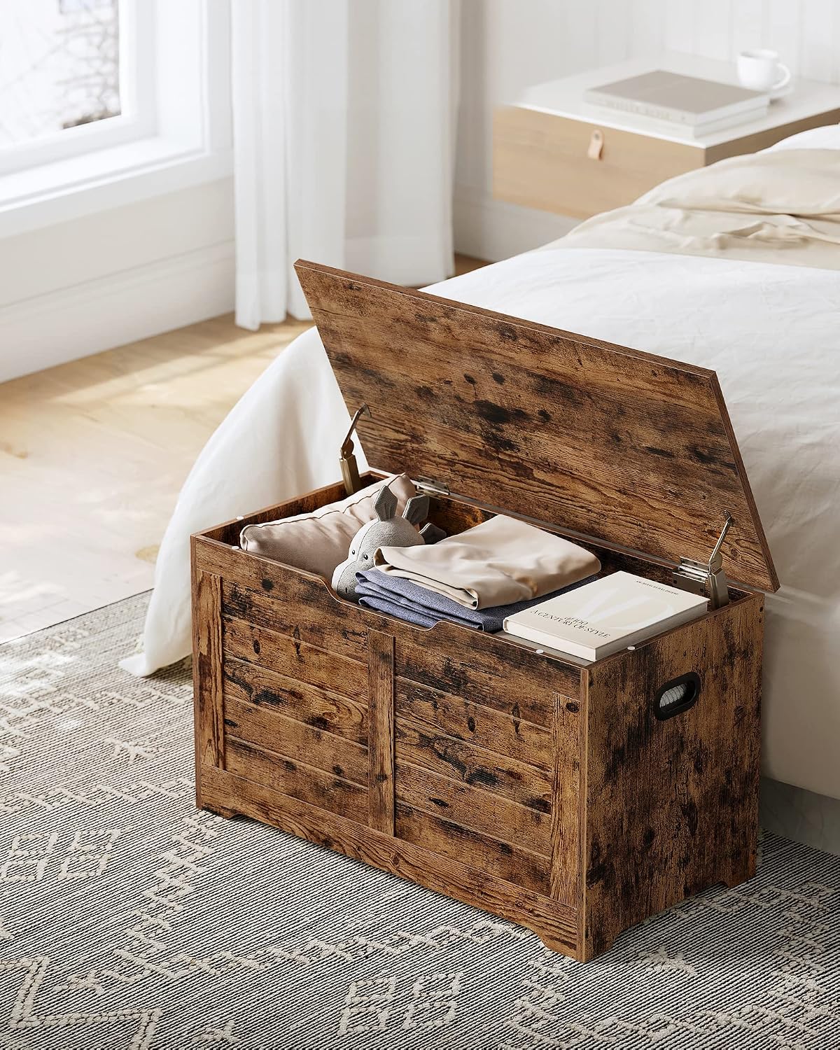 VASAGLE Storage Chest Bench with its lid open, revealing blankets and books stored inside.