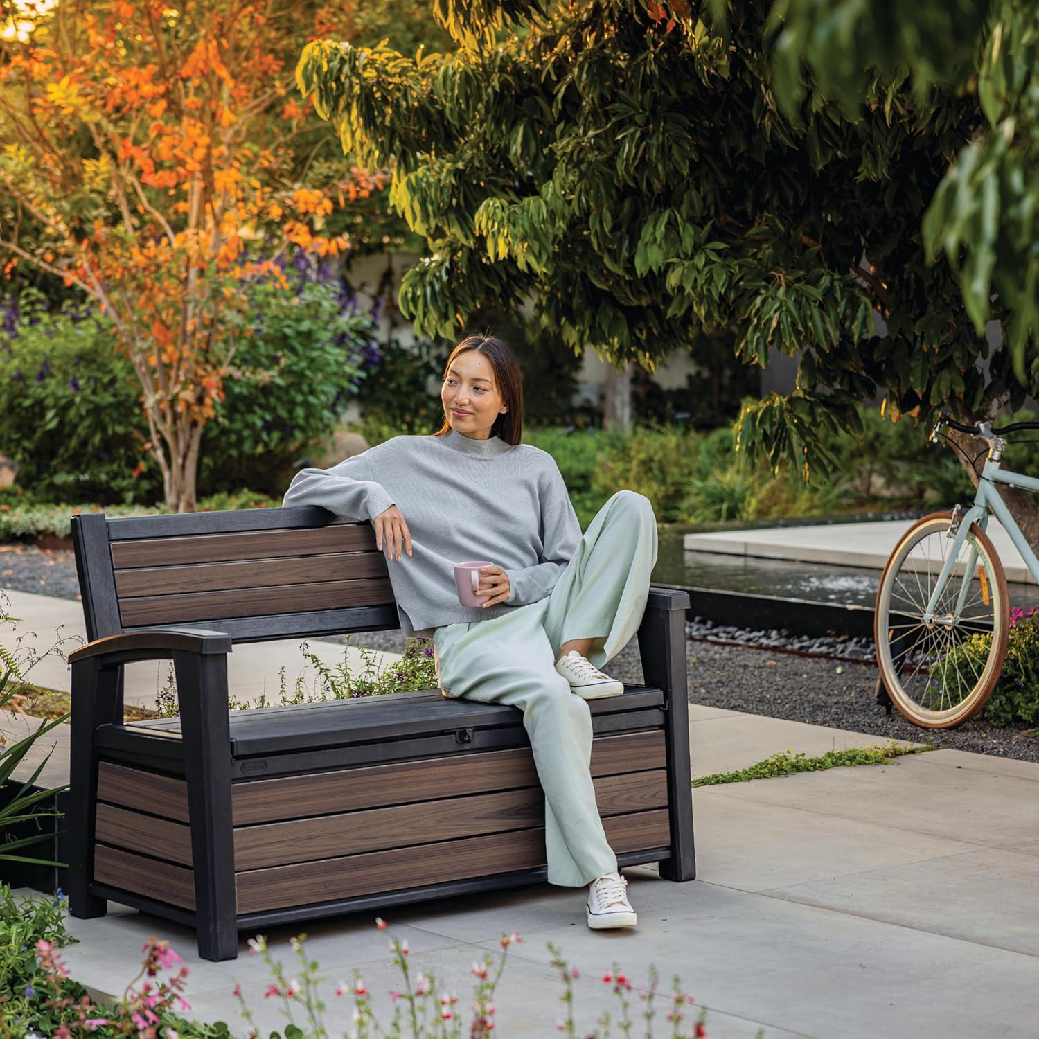 Woman sitting comfortably on the Keter Deco Garden Storage Bench