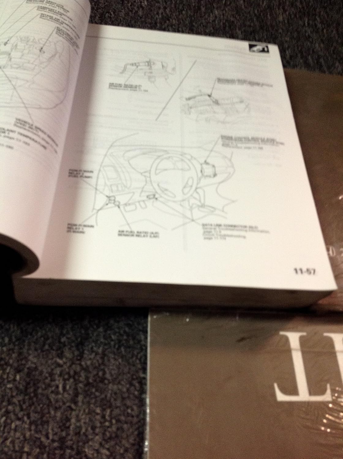 Open service manual page displaying a detailed diagram of vehicle components, possibly related to wiring or a system layout, with accompanying text.