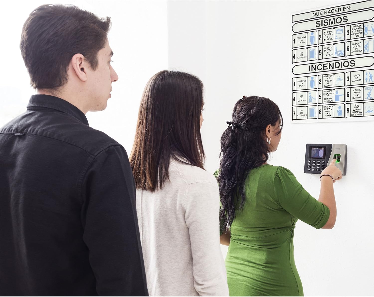 People using the Steren CLK-950 time clock for attendance, showing a user placing their finger on the scanner
