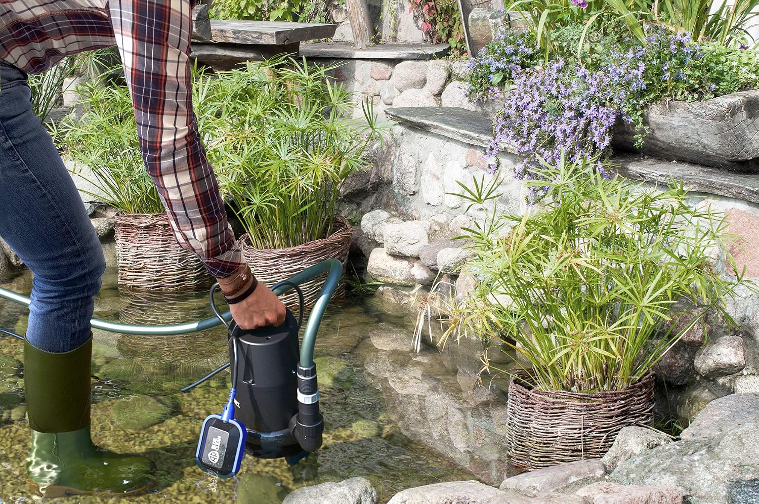 Person placing AR BLUE CLEAN ARUP 750PT pump into a pond