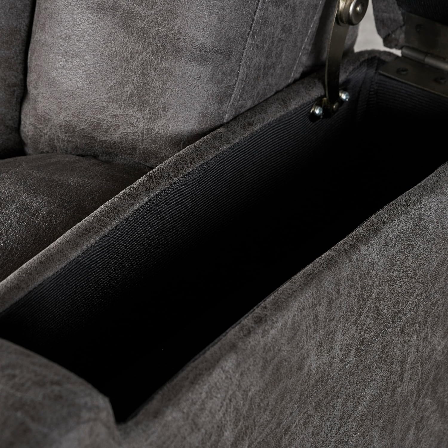 Close-up of the recliner's armrest showing the open storage compartment.