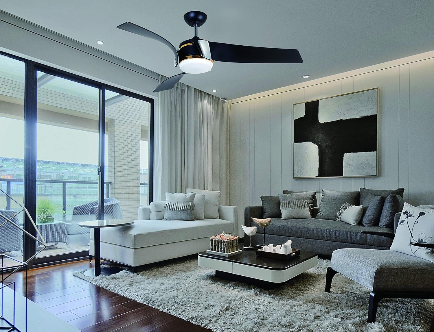 Vento ARCO ceiling fan installed in a modern living room with a sofa, coffee table, and large windows.