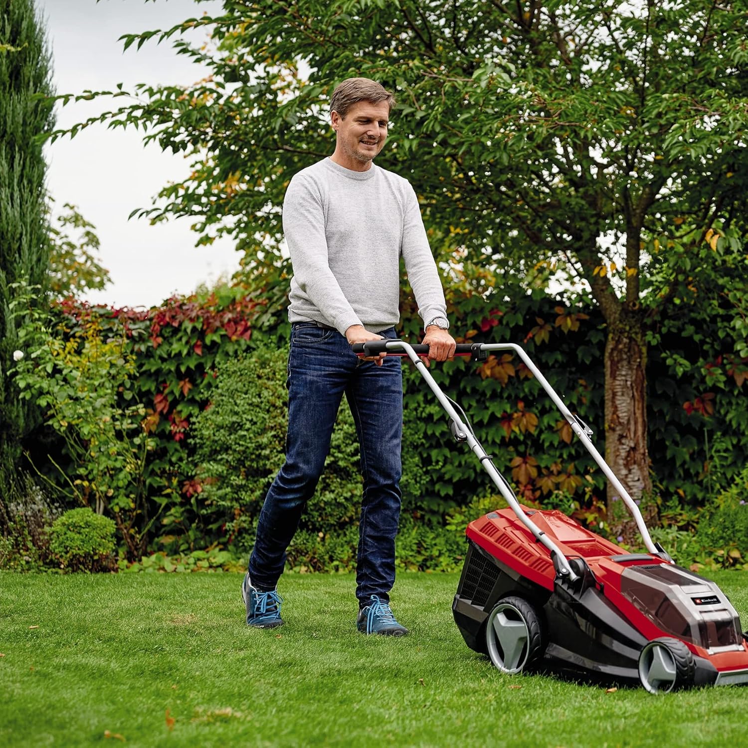 Man operating Einhell GE-CM 36/36 Li Cordless Lawnmower in a garden