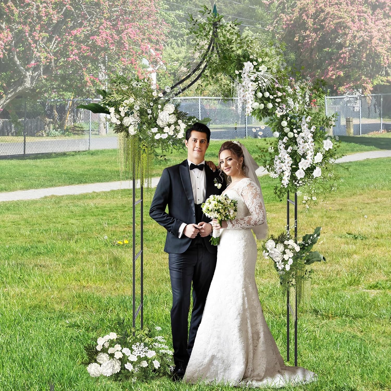 Wedding arch decorated with flowers and a couple standing beneath it