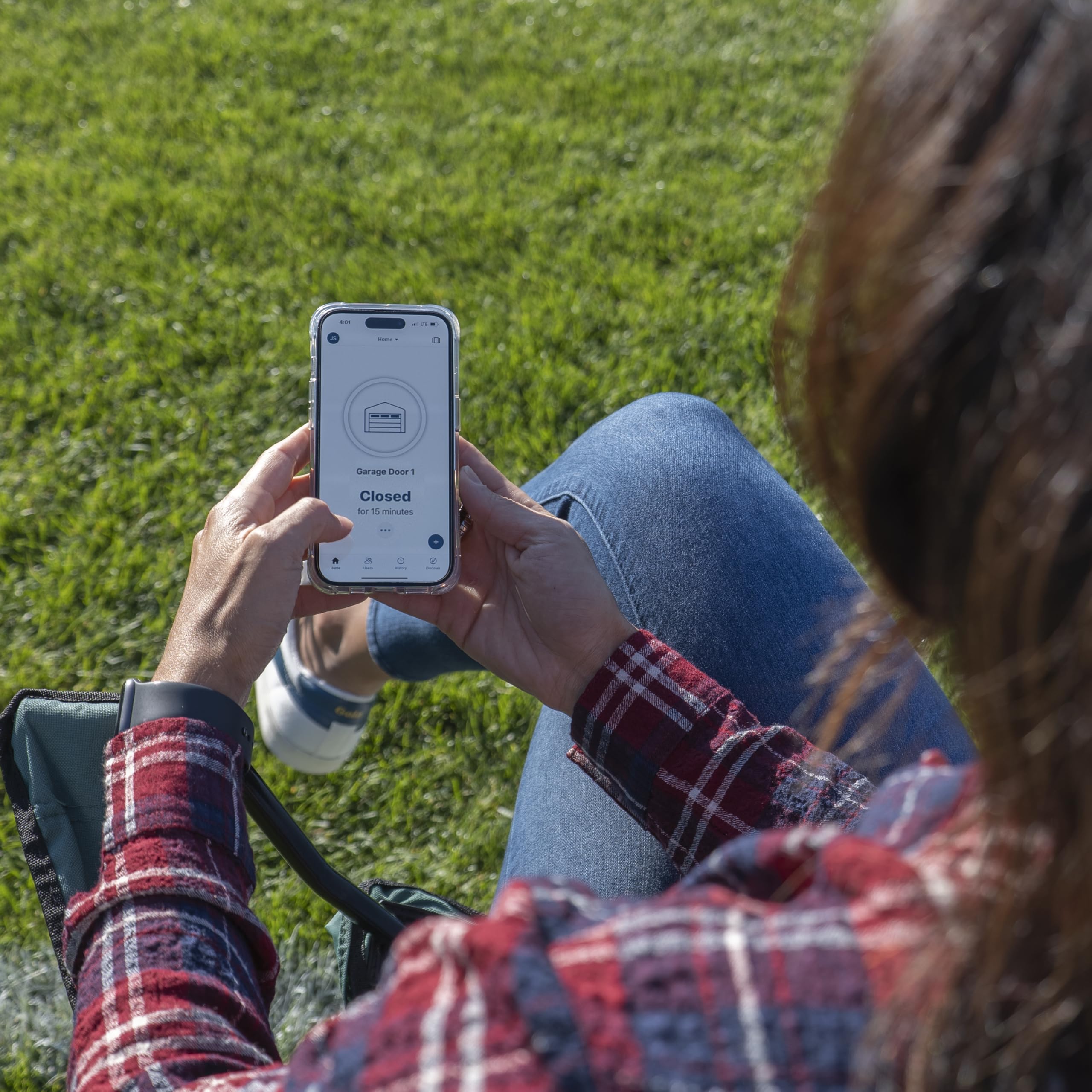 Person using a smartphone to control a garage door opener via the myQ app
