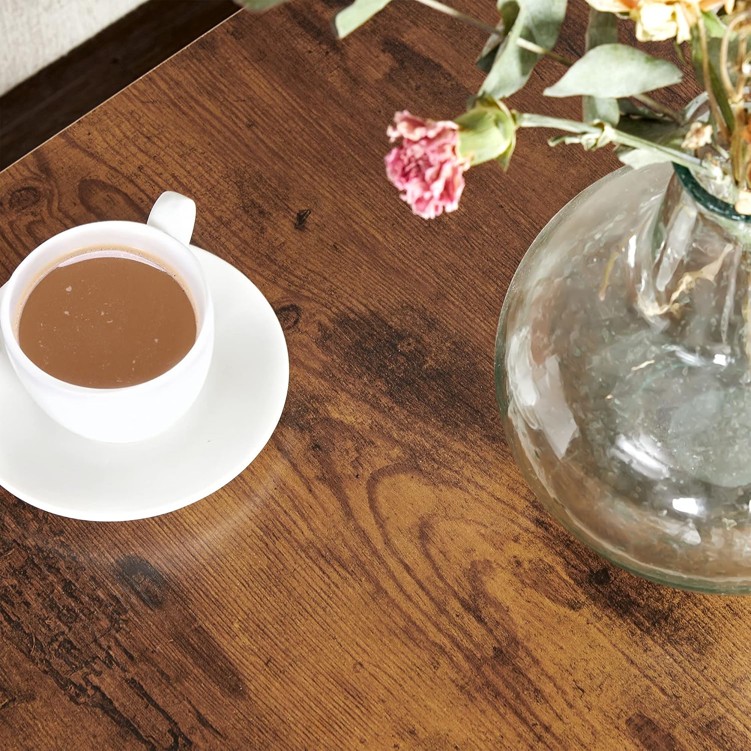 Close-up of the rustic brown wooden tabletop with a coffee cup and vase