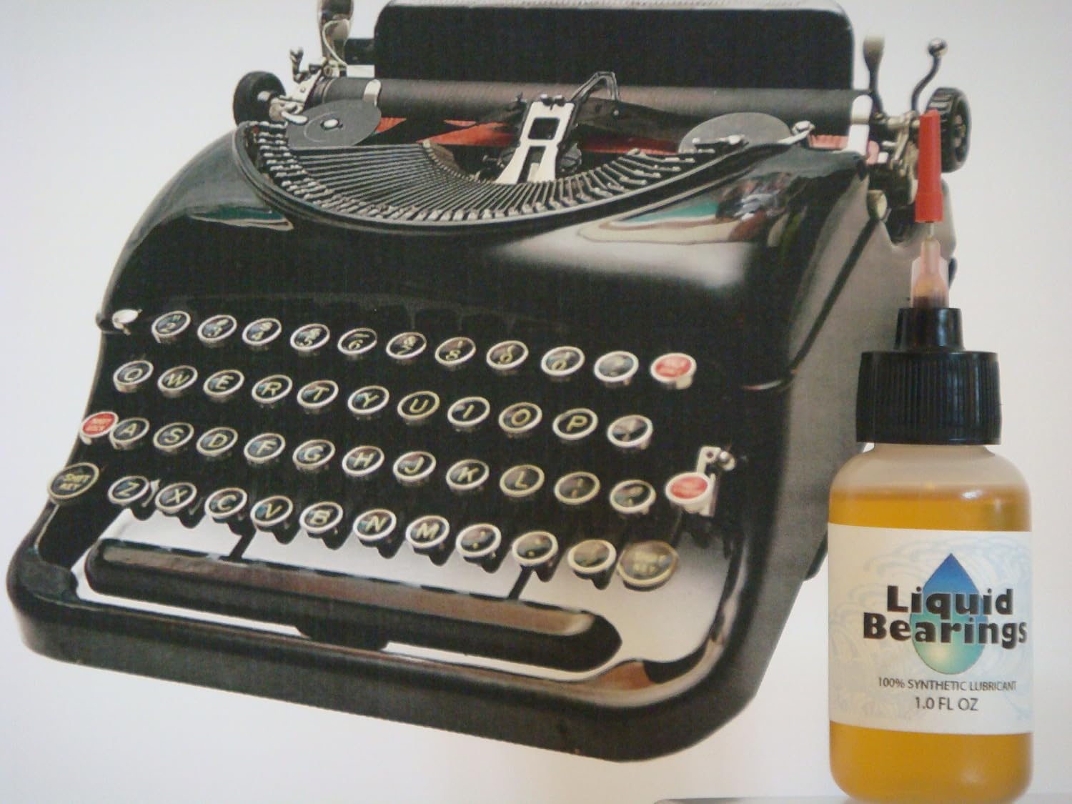 Liquid Bearings bottle next to a vintage black typewriter