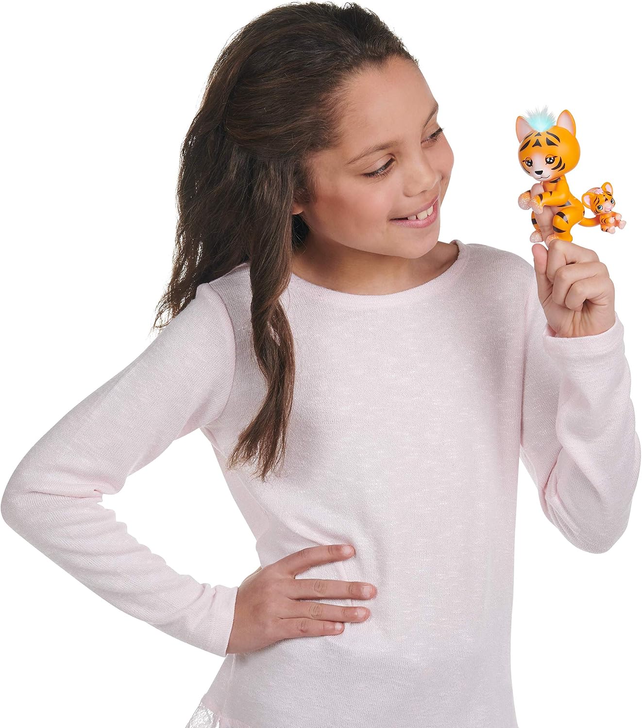 A child smiling while interacting with the WowWee Fingerlings Light-Up Baby Black Panther on their finger.