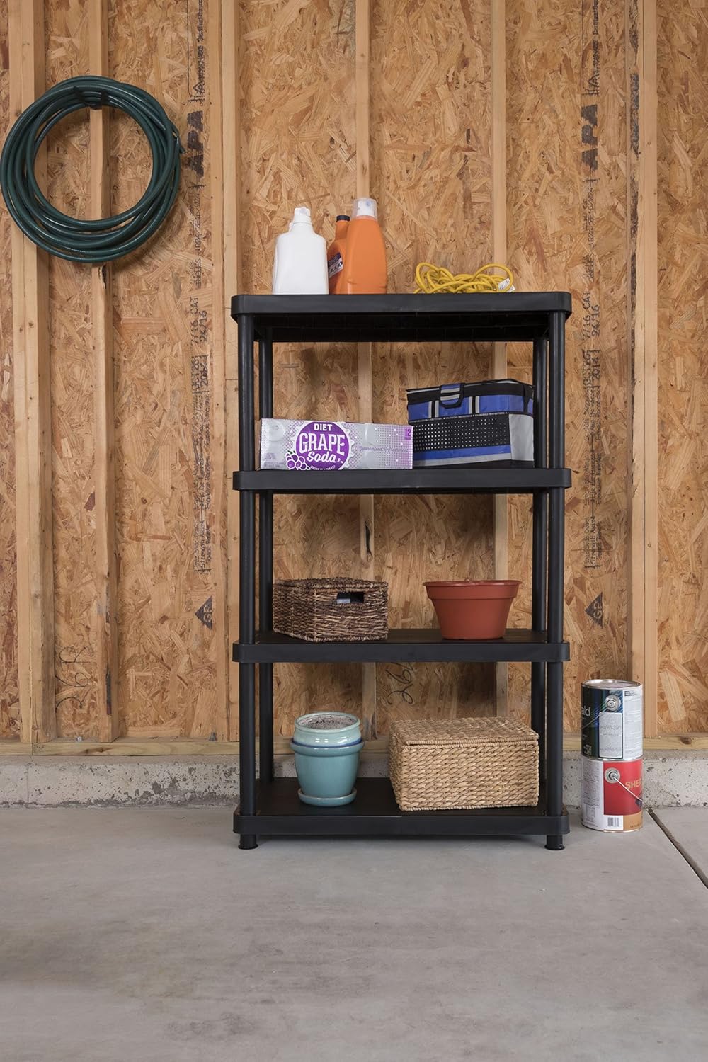 Keter 4-tier shelving unit fully loaded with various items in a garage setting.