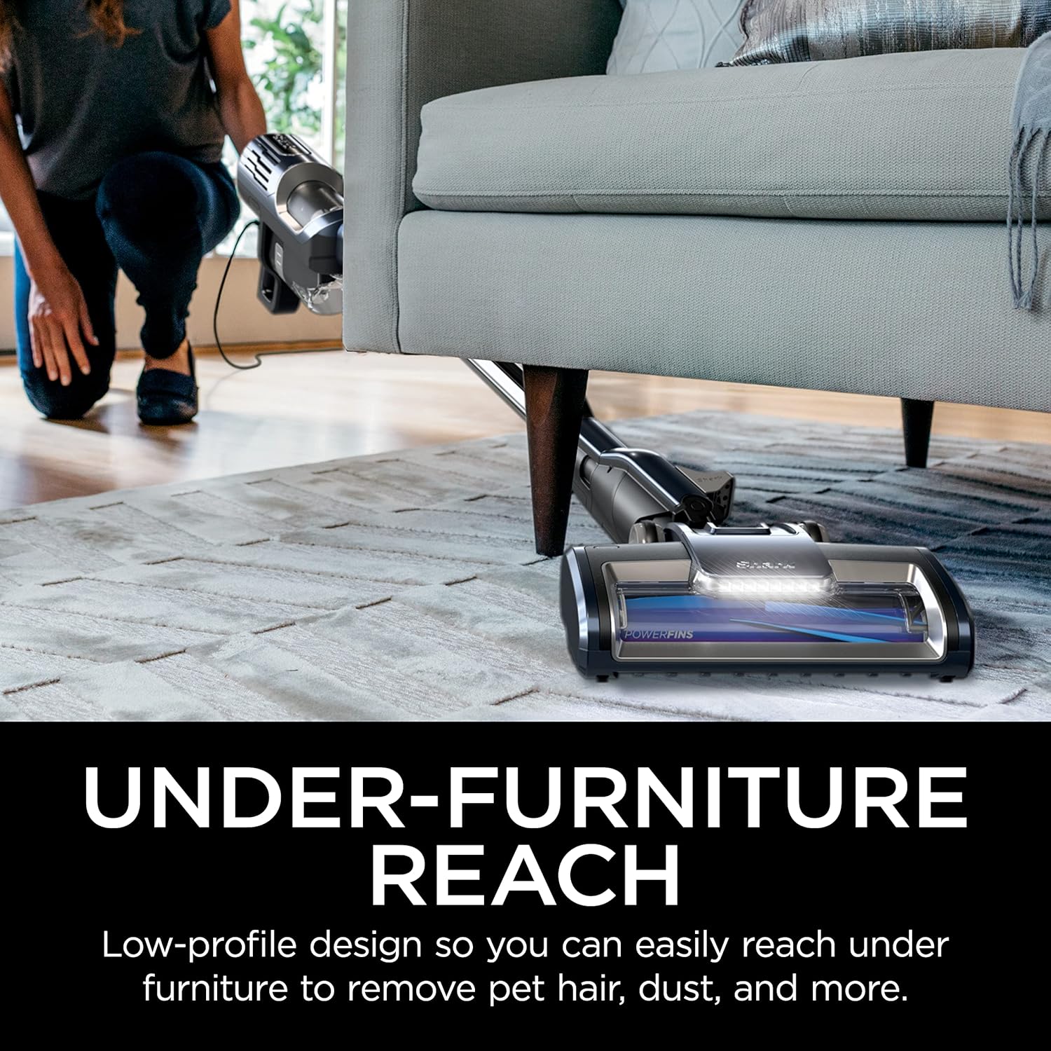 A person using the Shark HZ600C handheld vacuum with an attachment to clean pet hair from a sofa, with a small dog nearby.