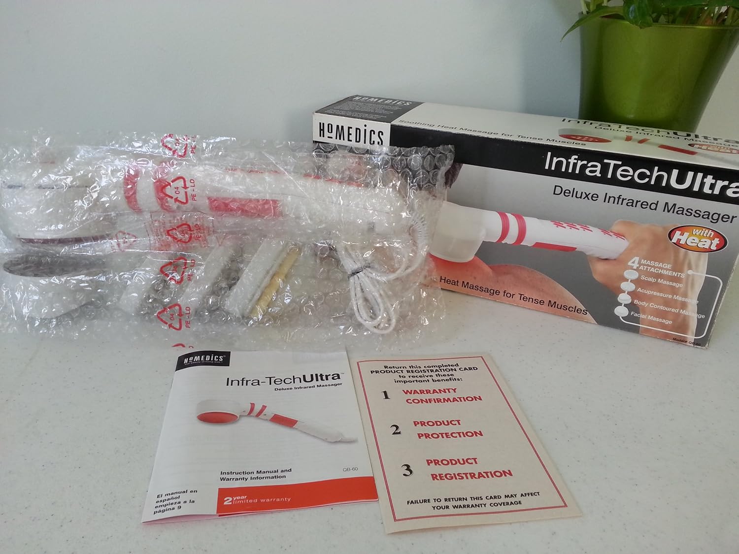 Contents of the Homedics Infra-tech Ultra Deluxe Infrared Massager package, including the massager, attachments, manual, and warranty card.