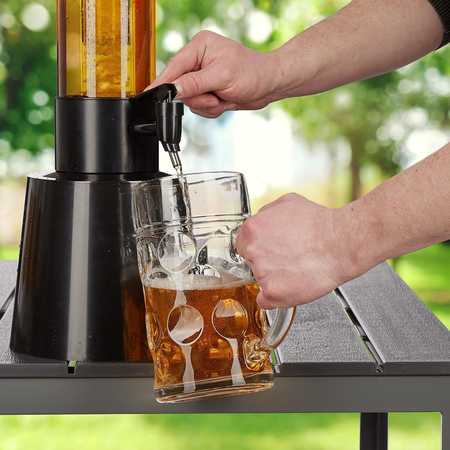 Person pouring beer from the Relaxdays dispenser into a large glass mug.