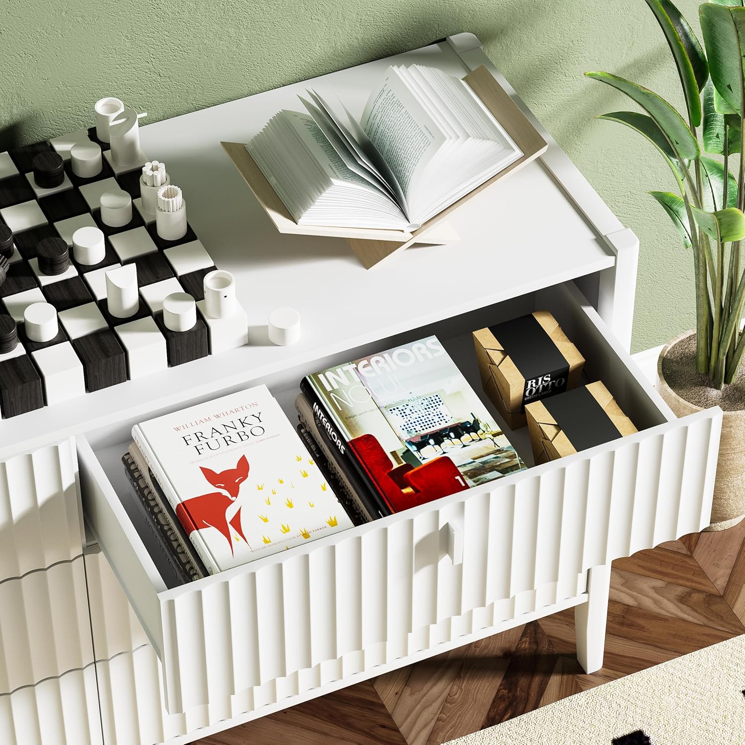 Close-up of an open dresser drawer filled with books and decorative boxes