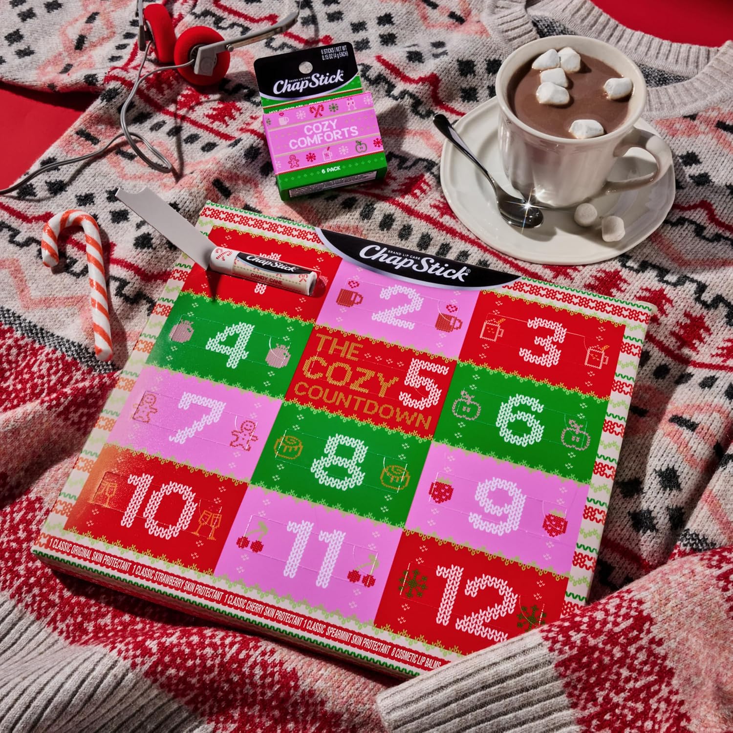 ChapStick twelve day lip balm advent calendar on a knit blanket beside hot cocoa
