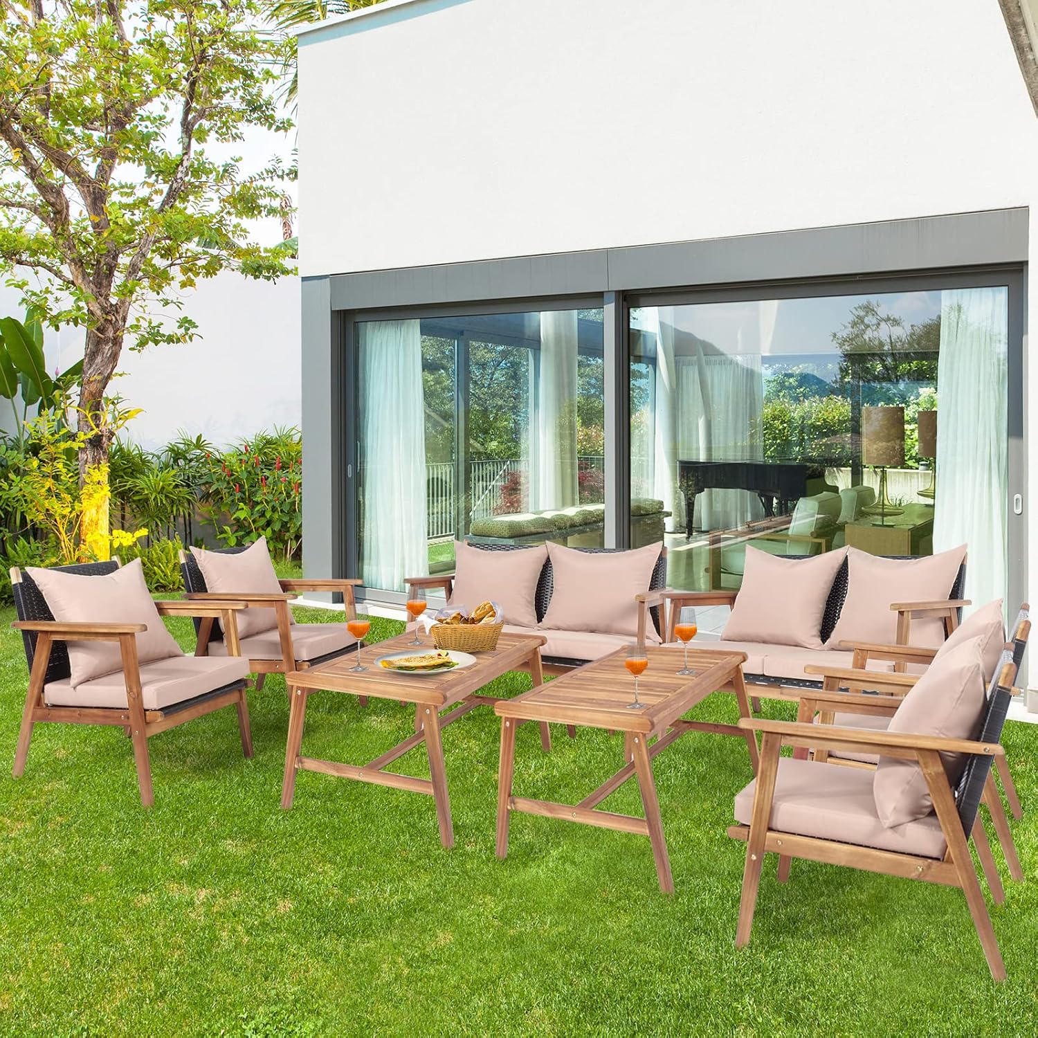 Patio furniture set arranged on a lawn outside a modern house
