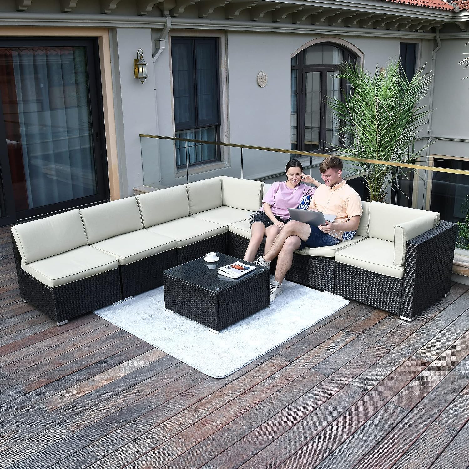 A couple relaxing on the YITAHOME patio furniture set on a wooden deck.