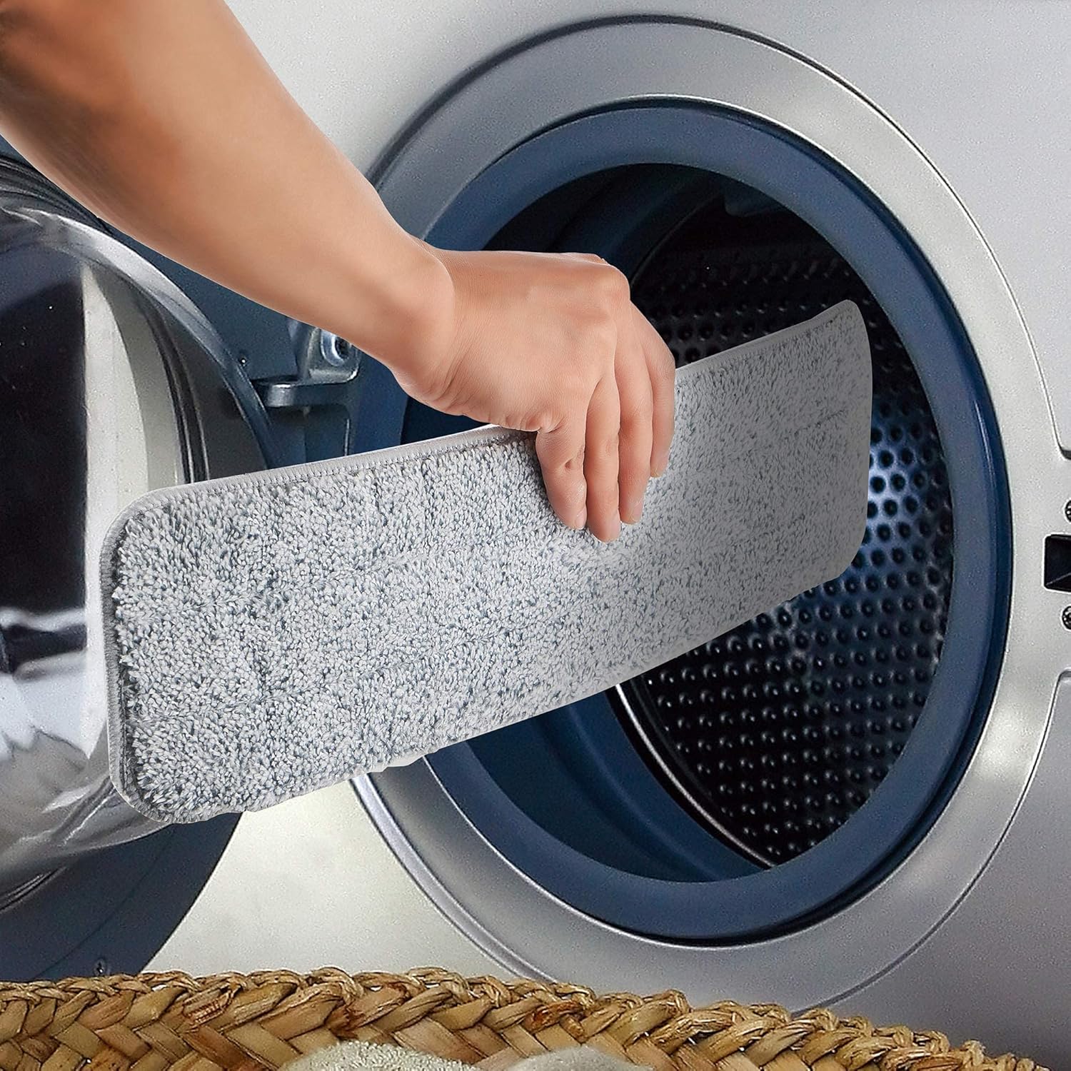 A microfiber mop pad being placed into a washing machine