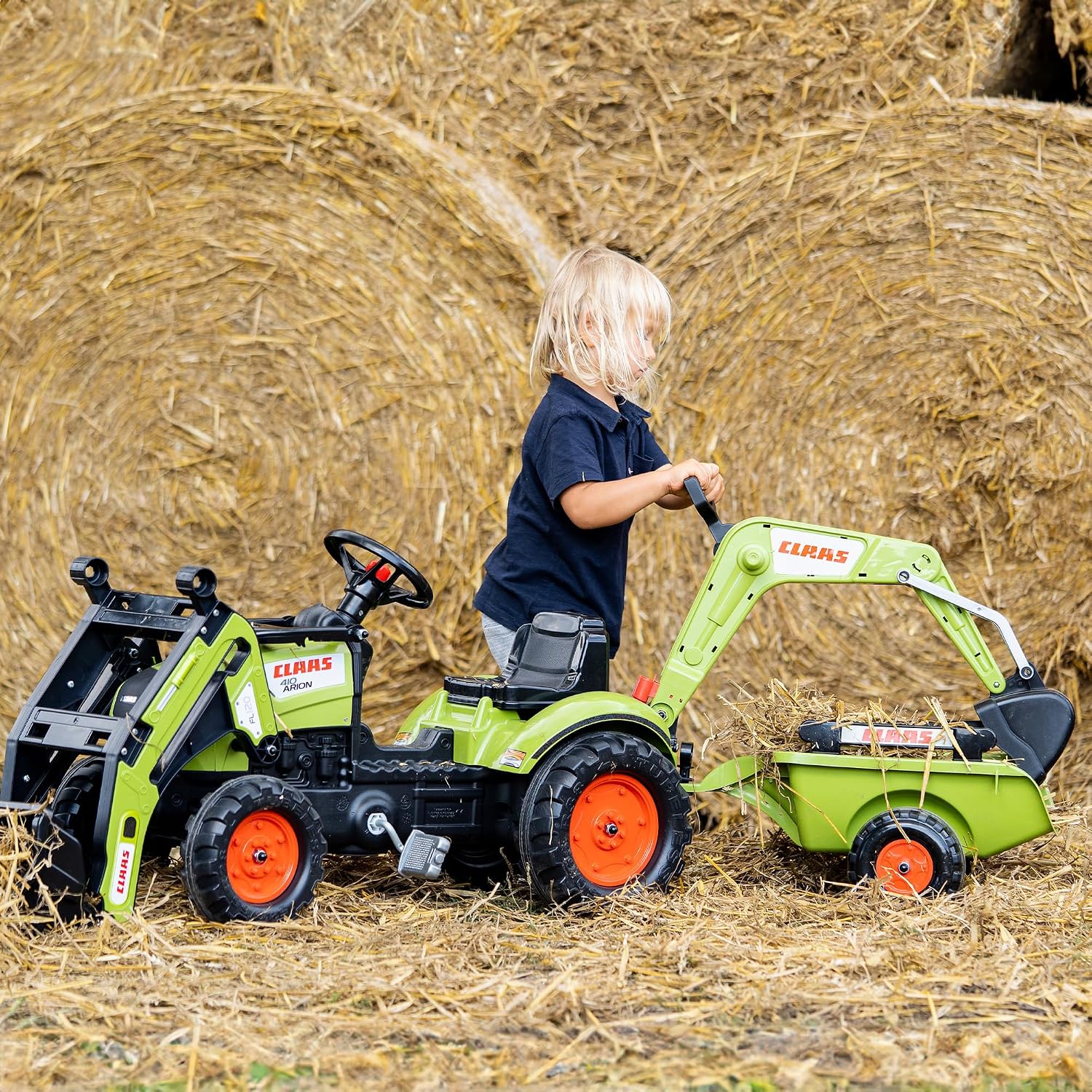 Child operating the rear excavator of the tractor in a hay field
