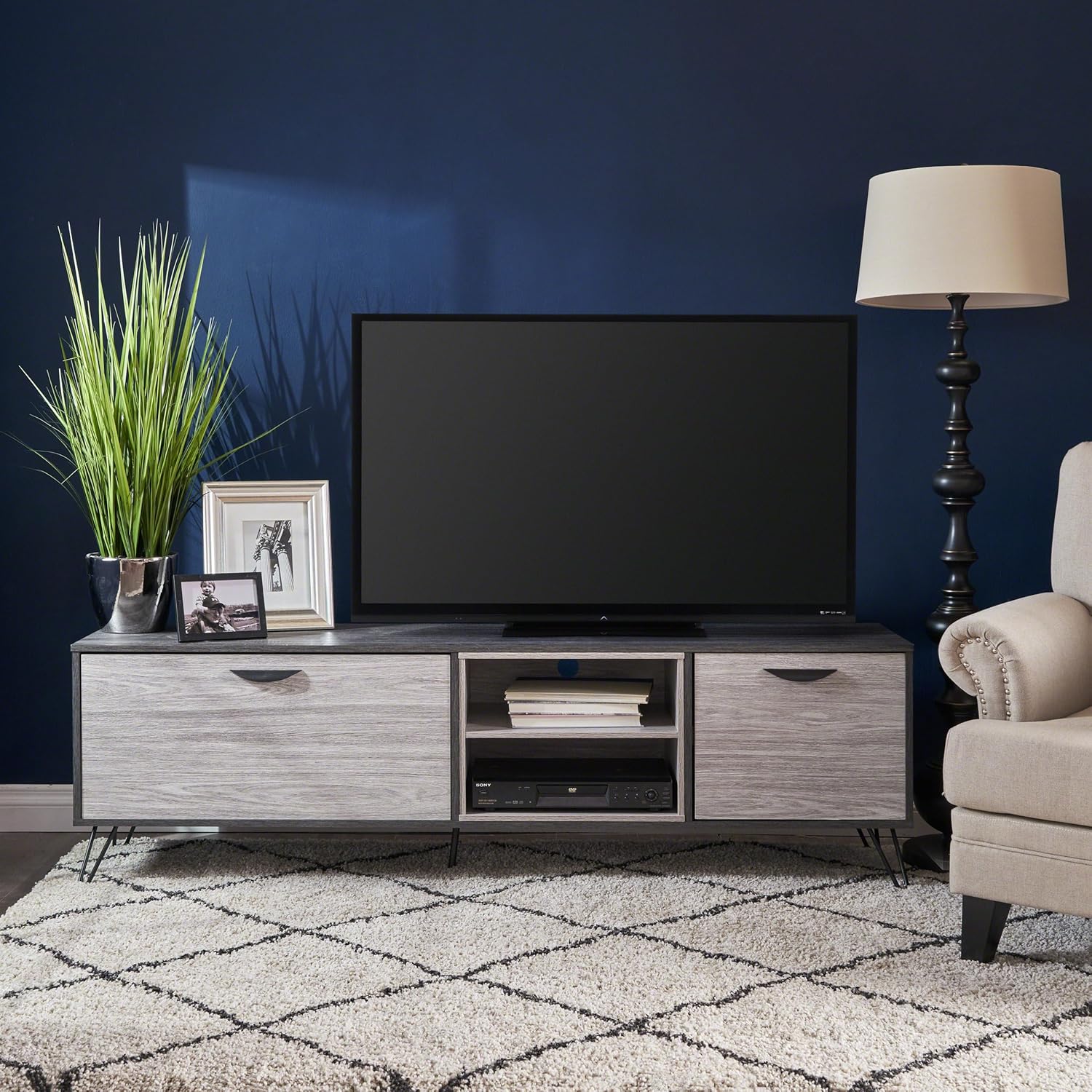 The UJoylify TV stand with a television placed on top and media devices in the open shelves, illustrating its functional use.