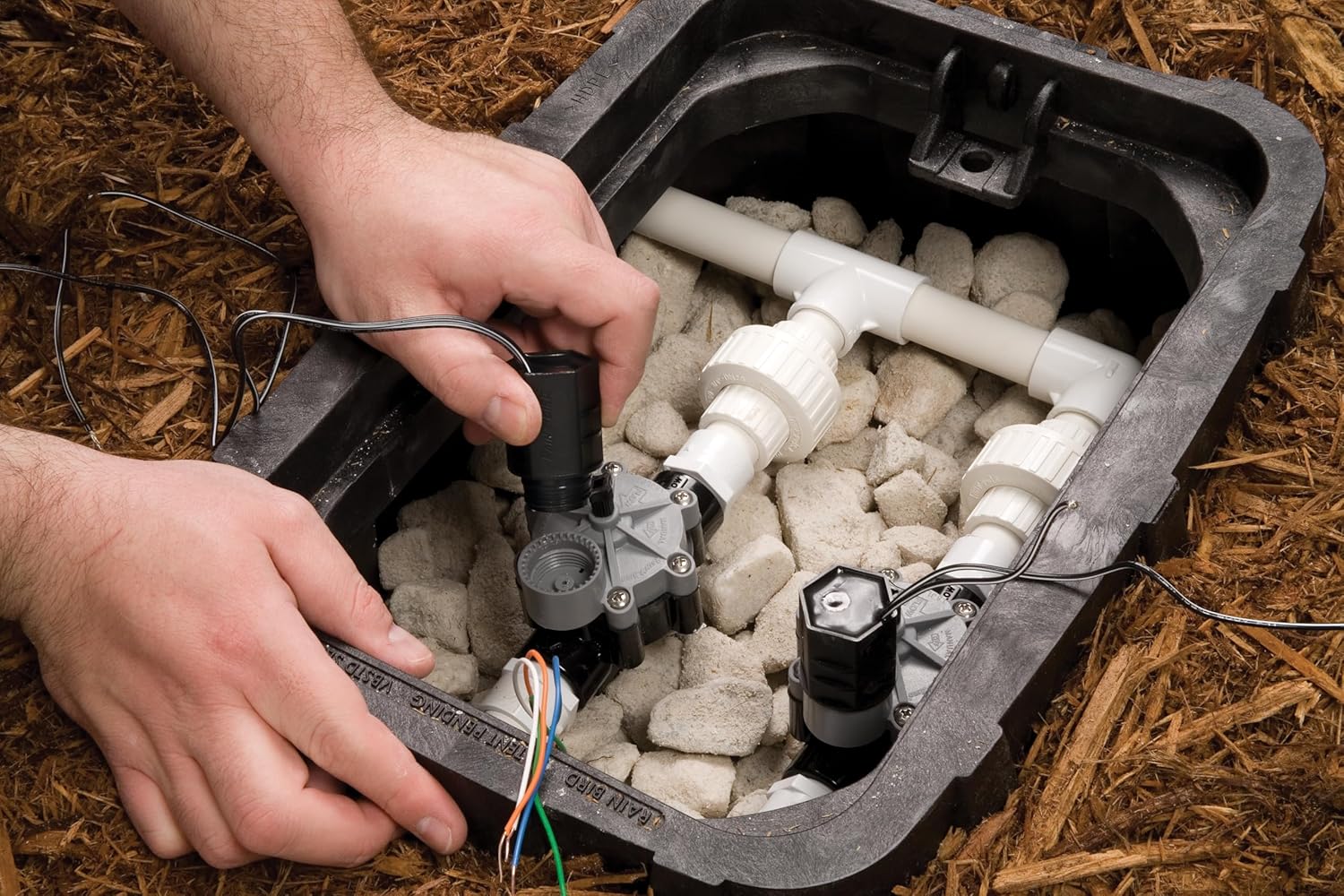 Hands installing a Rain Bird solenoid into a valve
