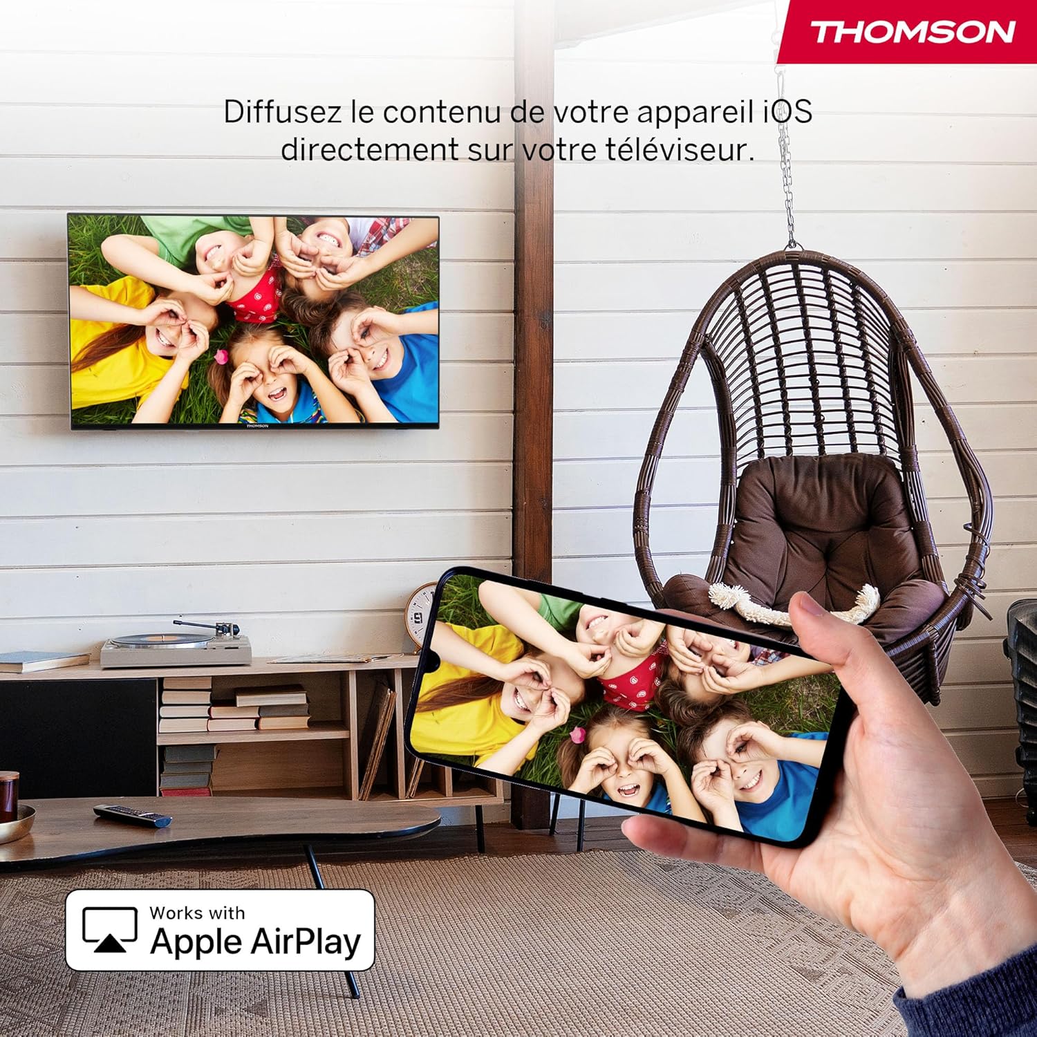 Image demonstrating Apple AirPlay functionality, with an iPhone mirroring content to the Thomson TV.