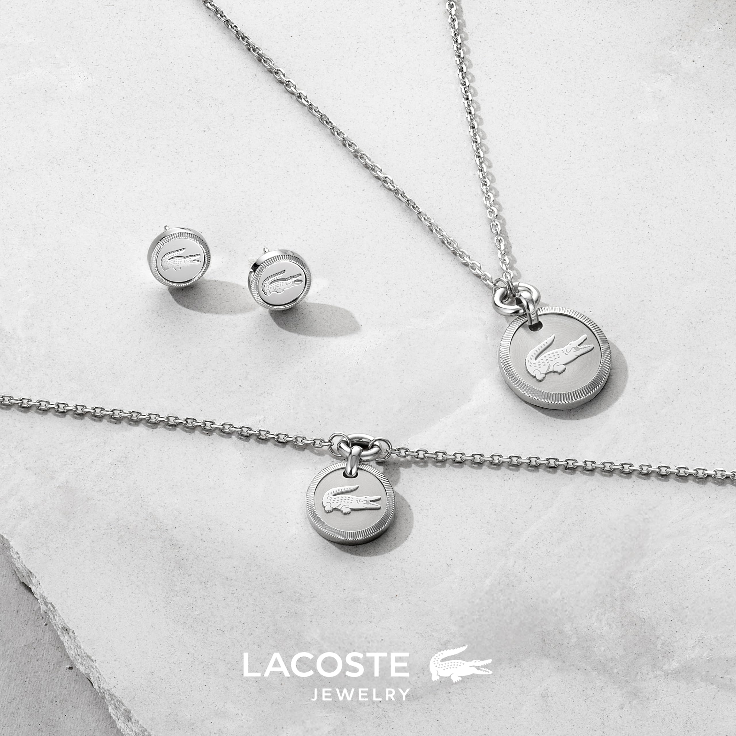 Lacoste Jewelry para Mujer Colección MEMENTO Collar, Pulsera o Pendientes de Botón en Acero Inoxidable con Colgante Grabado de Cocodrilo