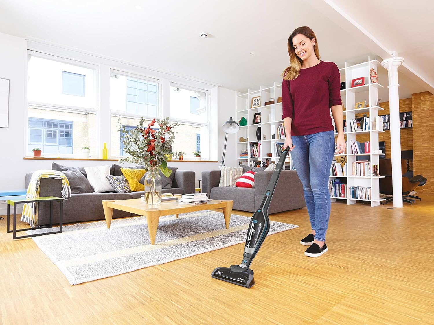 User cleaning a sofa with the BLACK+DECKER SVA420B-B5 handheld vacuum