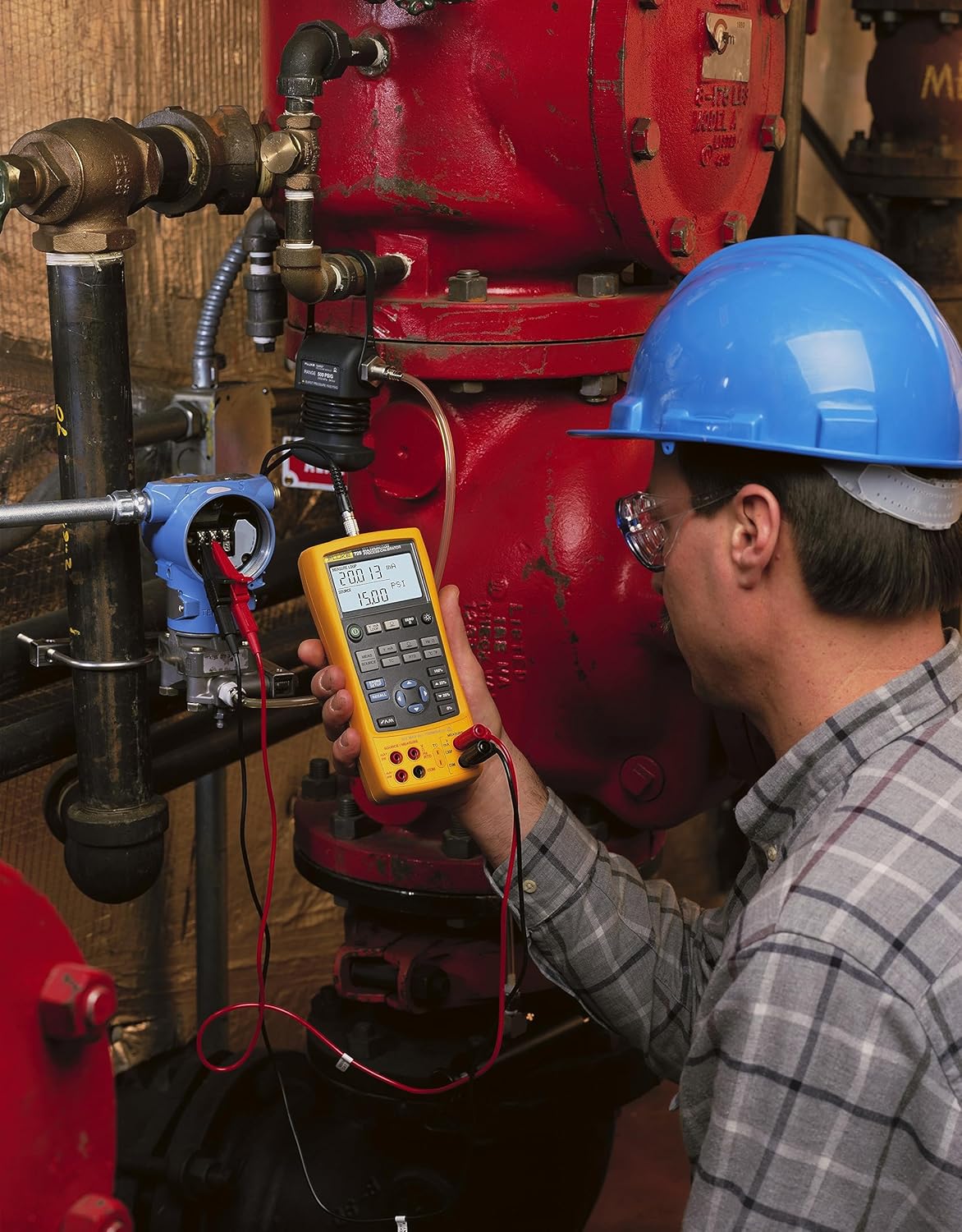 Fluke 725 calibrator connected to a pressure transmitter in an industrial setting